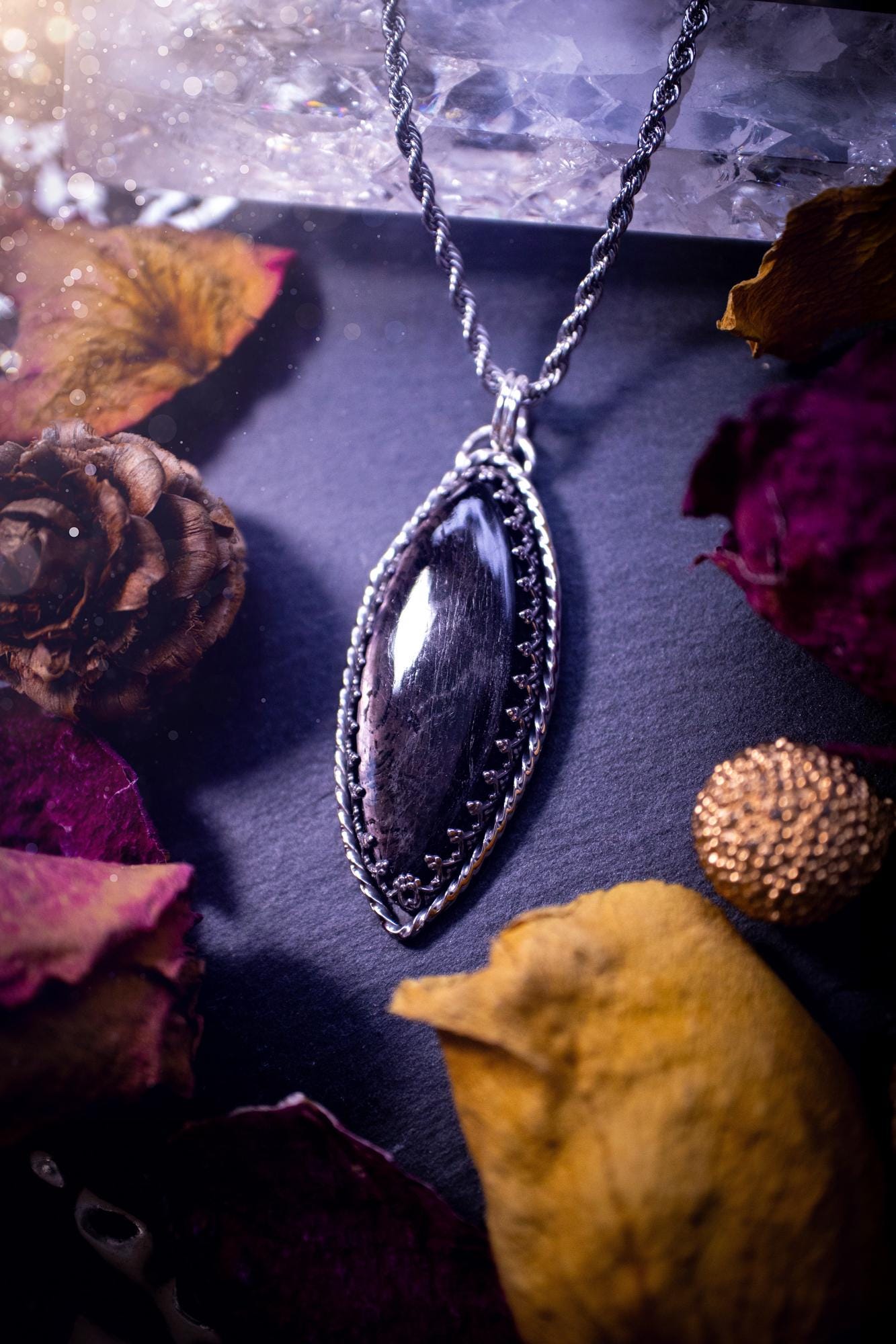 Beautifully handmade, and natural hypersthene crystal, sterling silver pendant necklace. This stunning pendant necklace features a marquise shaped hypersthene crystal gemstone that is full of shimmering silver flash. Rocking a minimalistic design with a gallery wire bezel to give off gothic and witchy vibes. This piece would be ideal as a gift for any jewellery and crystal lover, or even for yourself as a treat.