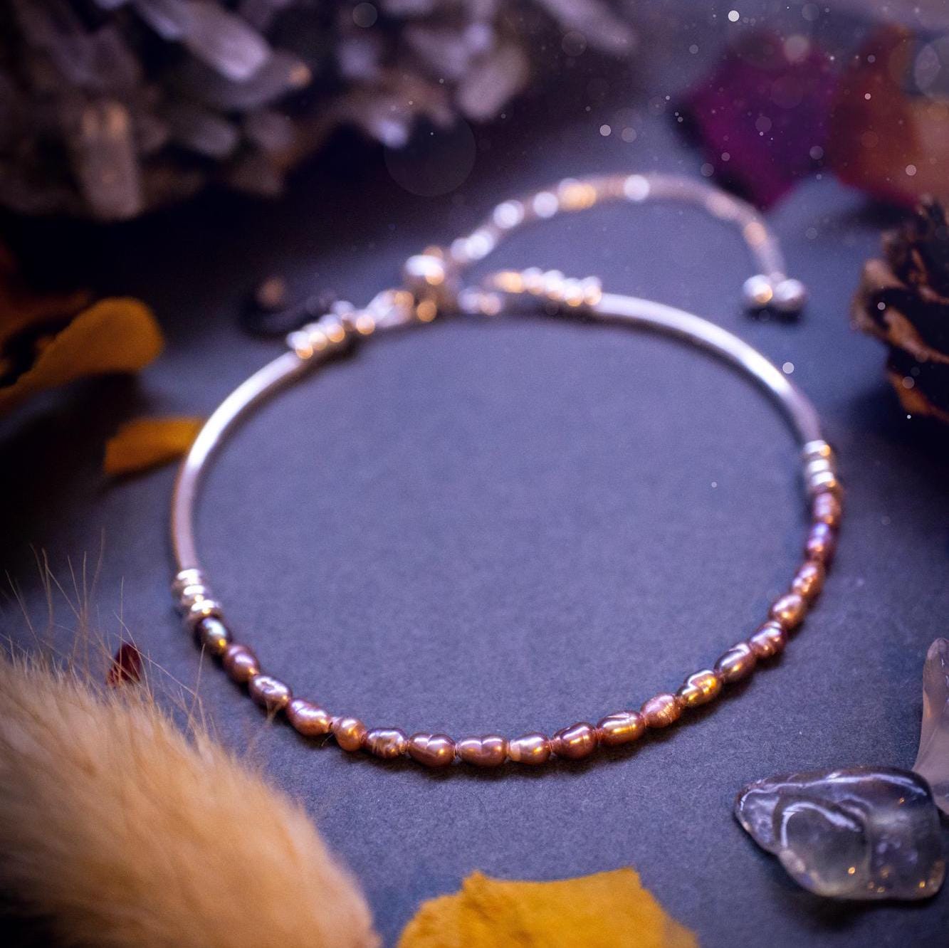 Beautifully handcrafted, pink mother of pearl, sterling silver, slider, stacker bracelet. This bracelet has high quality fresh water pearls that have been strung on 49 strand beading wire which is very strong yet gives a beautiful drape across the wrist. Featuring sterling silver spacer beads, a little moon charm and a bracelet slider as the clasp. This bracelet  would make the ideal gift for crystal lovers and would suit any outfit.