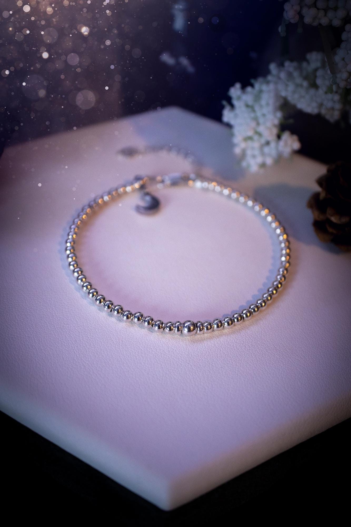 Beautiful and handmade, 3mm beaded, sterling silver stacking bracelet. This bracelet has been made using high quality sterling silver beads which have bee strung on strong 49 strand beading wire. This wire is very strong, but also gives a beautiful drape across the wrist. Featuring one larger silver spacer bead in the middle with rondelle beads either side to give some uniqueness. This bracelet is ideal for stacking with others, and makes a lovely gift for jewellery lovers.