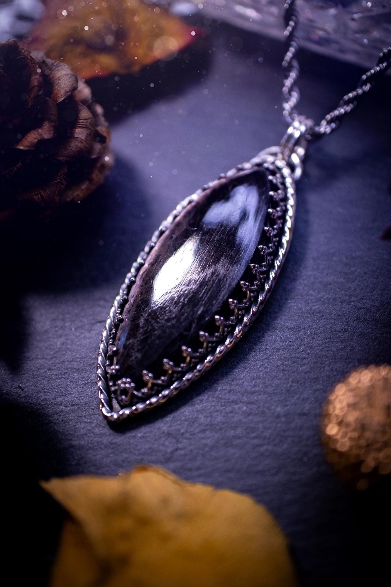 Beautifully handmade, and natural hypersthene crystal, sterling silver pendant necklace. This stunning pendant necklace features a marquise shaped hypersthene crystal gemstone that is full of shimmering silver flash. Rocking a minimalistic design with a gallery wire bezel to give off gothic and witchy vibes. This piece would be ideal as a gift for any jewellery and crystal lover, or even for yourself as a treat.