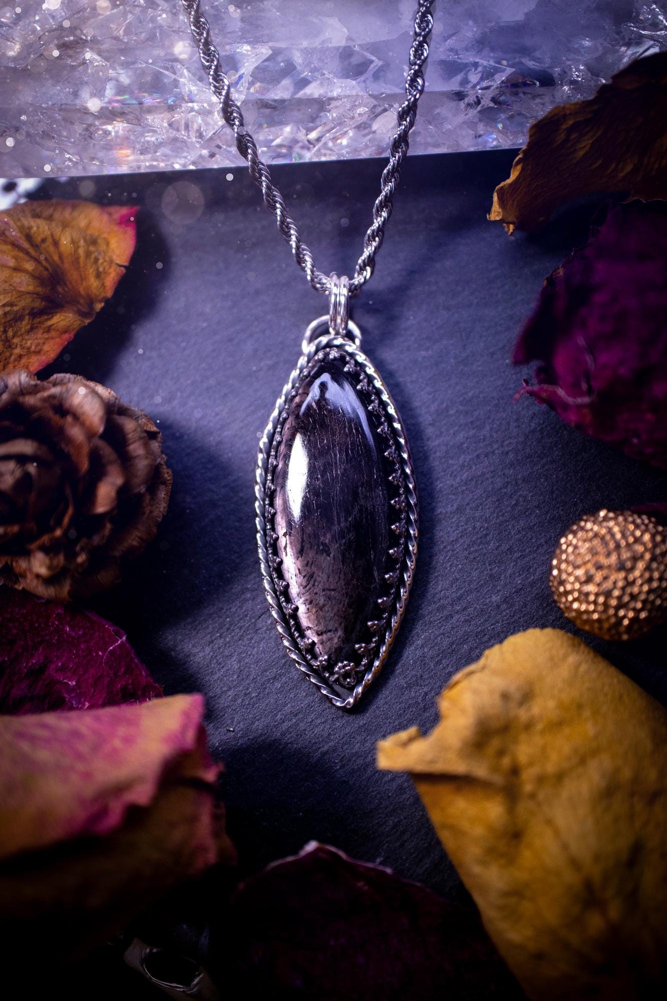 Beautifully handmade, and natural hypersthene crystal, sterling silver pendant necklace. This stunning pendant necklace features a marquise shaped hypersthene crystal gemstone that is full of shimmering silver flash. Rocking a minimalistic design with a gallery wire bezel to give off gothic and witchy vibes. This piece would be ideal as a gift for any jewellery and crystal lover, or even for yourself as a treat.