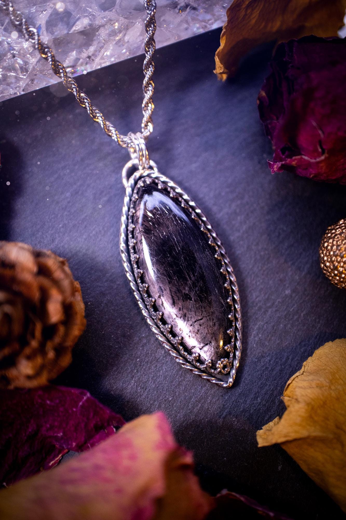 Beautifully handmade, and natural hypersthene crystal, sterling silver pendant necklace. This stunning pendant necklace features a marquise shaped hypersthene crystal gemstone that is full of shimmering silver flash. Rocking a minimalistic design with a gallery wire bezel to give off gothic and witchy vibes. This piece would be ideal as a gift for any jewellery and crystal lover, or even for yourself as a treat.