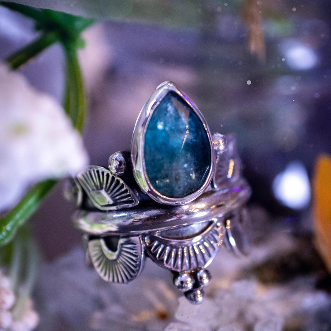 Beautiful and one of a kind, deep blue aqua kyanite crystal, statement ring. Size O 1/2. This stunning and unique ring has been handmade using a high grade kyanite crystal. The kyanite is rose cut giving a gorgeous sparkle, it even has a little shimmering flash. Made from recycled fine and sterling silver and designed with different stamps on a wide band. A very pretty piece to gift to a loved one or to treat yourself. Bohemian, gothic and witchy crystal jewellery.