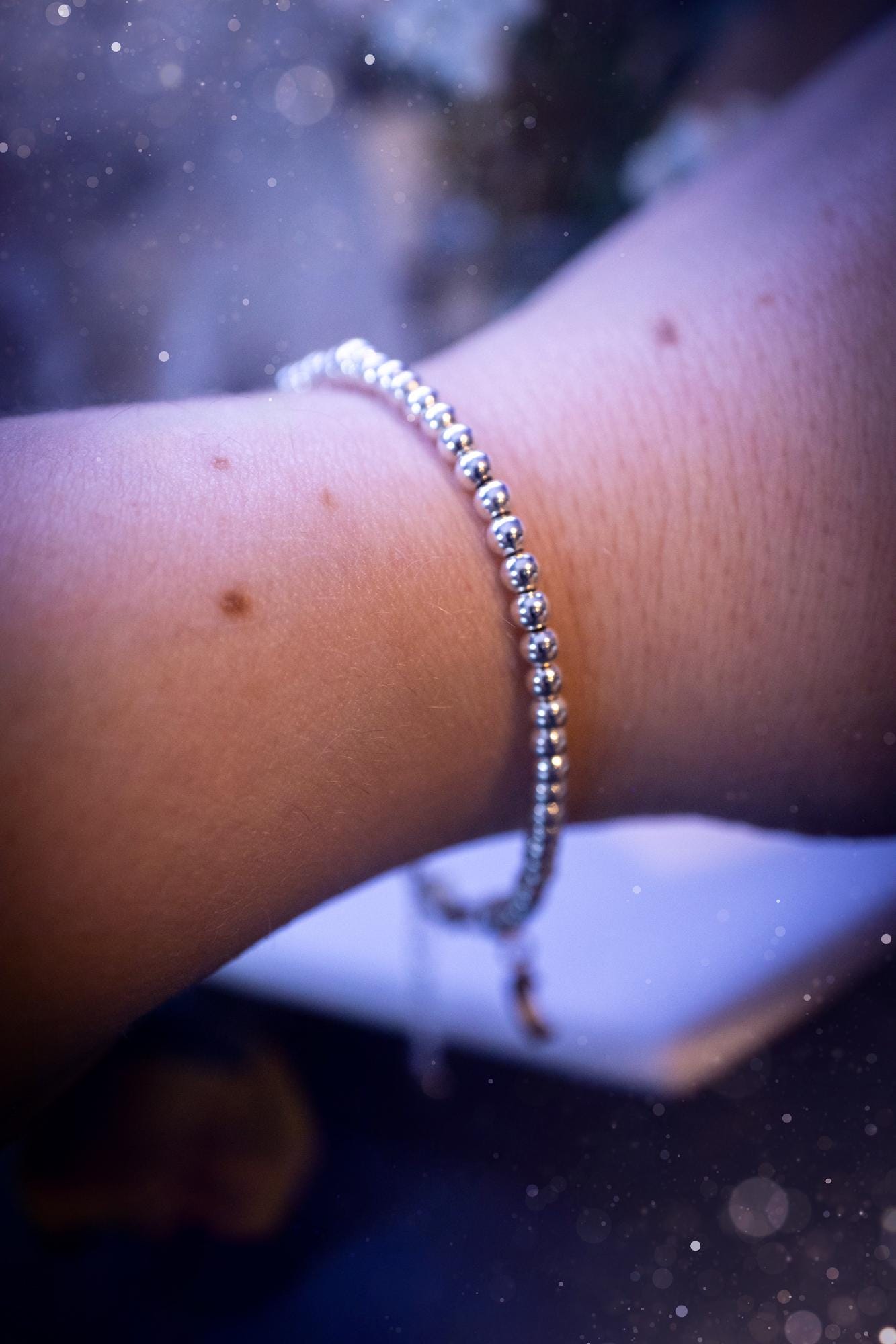 Beautiful and handmade, 3mm beaded, sterling silver stacking bracelet. This bracelet has been made using high quality sterling silver beads which have bee strung on strong 49 strand beading wire. This wire is very strong, but also gives a beautiful drape across the wrist. Featuring one larger silver spacer bead in the middle with rondelle beads either side to give some uniqueness. This bracelet is ideal for stacking with others, and makes a lovely gift for jewellery lovers.