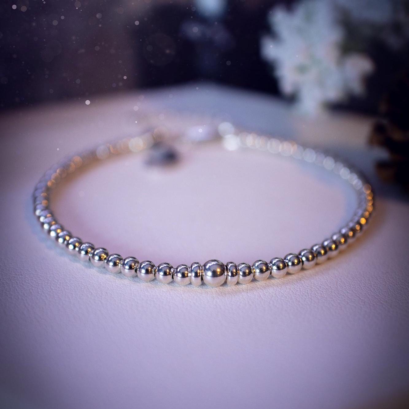 Beautiful and handmade, 3mm beaded, sterling silver stacking bracelet. This bracelet has been made using high quality sterling silver beads which have bee strung on strong 49 strand beading wire. This wire is very strong, but also gives a beautiful drape across the wrist. Featuring one larger silver spacer bead in the middle with rondelle beads either side to give some uniqueness. This bracelet is ideal for stacking with others, and makes a lovely gift for jewellery lovers.