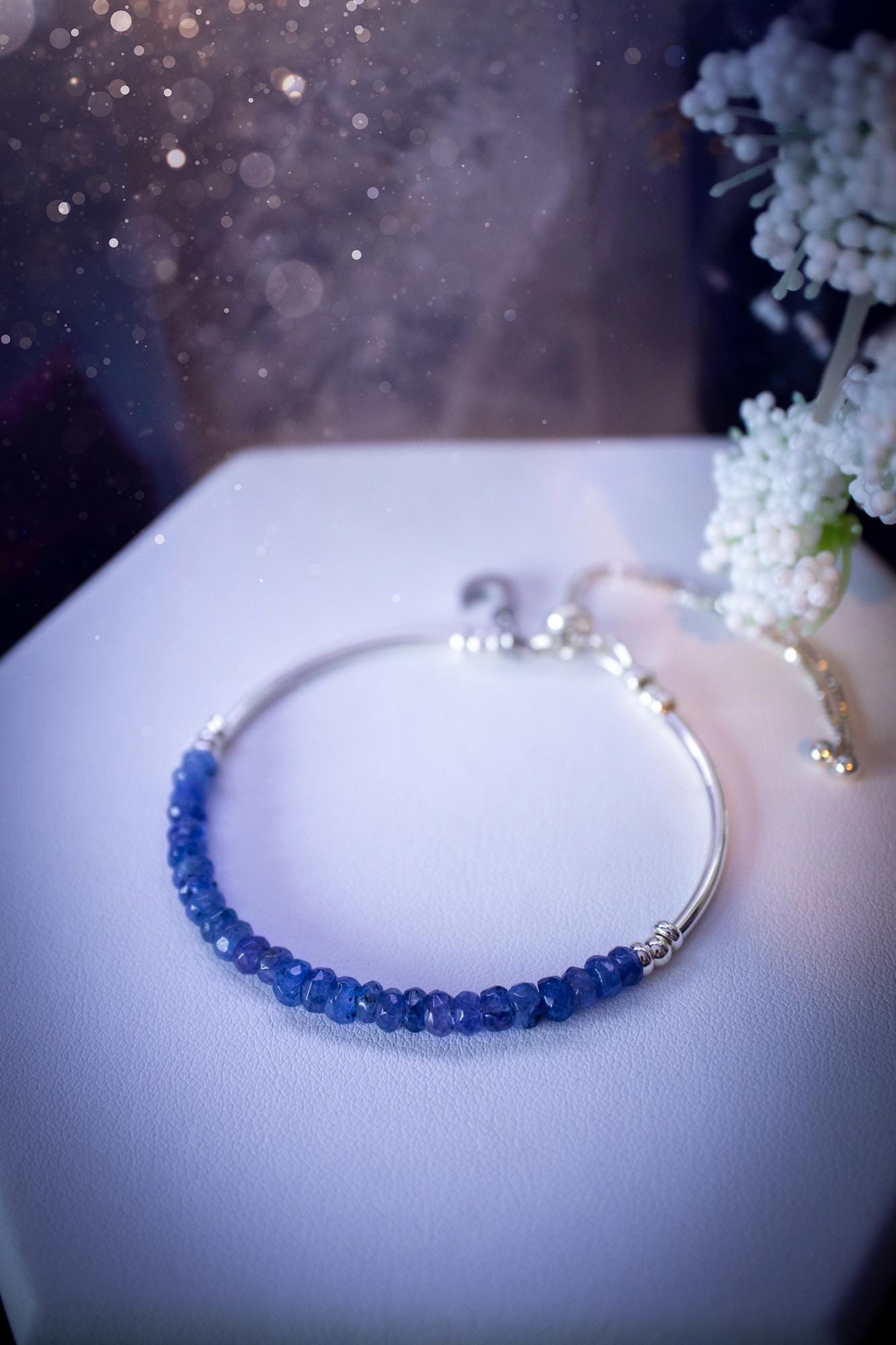 Beautiful and handmade, Tanzanite crystal nugget, sterling silver stacking bracelet. This bracelet has been made using high quality sterling silver beads which have bee strung on strong 49 strand beading wire. This wire is very strong, but also gives a beautiful drape across the wrist. Featuring beautiful and flashy tanzanite crystal nugget beads. This bracelet is ideal for stacking with others, and makes a lovely gift for jewellery lovers.