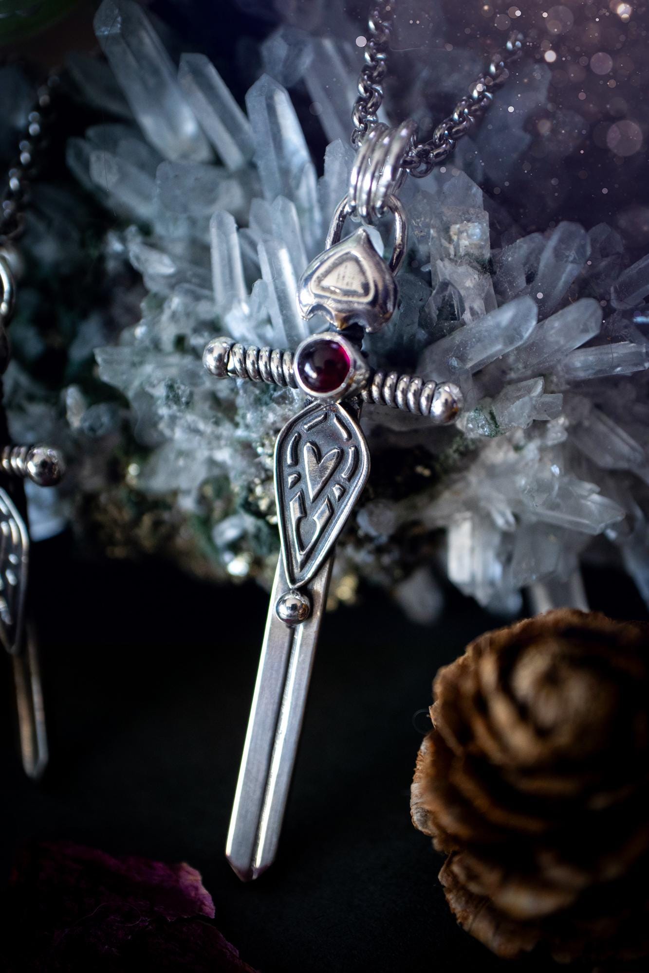 Handmade sterling silver pendant necklace in the shape of a sword, featuring a beautiful garnet as the centre piece. This piece of jewellery has been created using recycled fine and sterling silver and features a gorgeous garnet that is full of sparkle. Suitable or special occasions such as birthdays, anniversaries, graduations and more. Garnet is the birthstone for January. Witchy and gothic handmade jewellery, medieval.