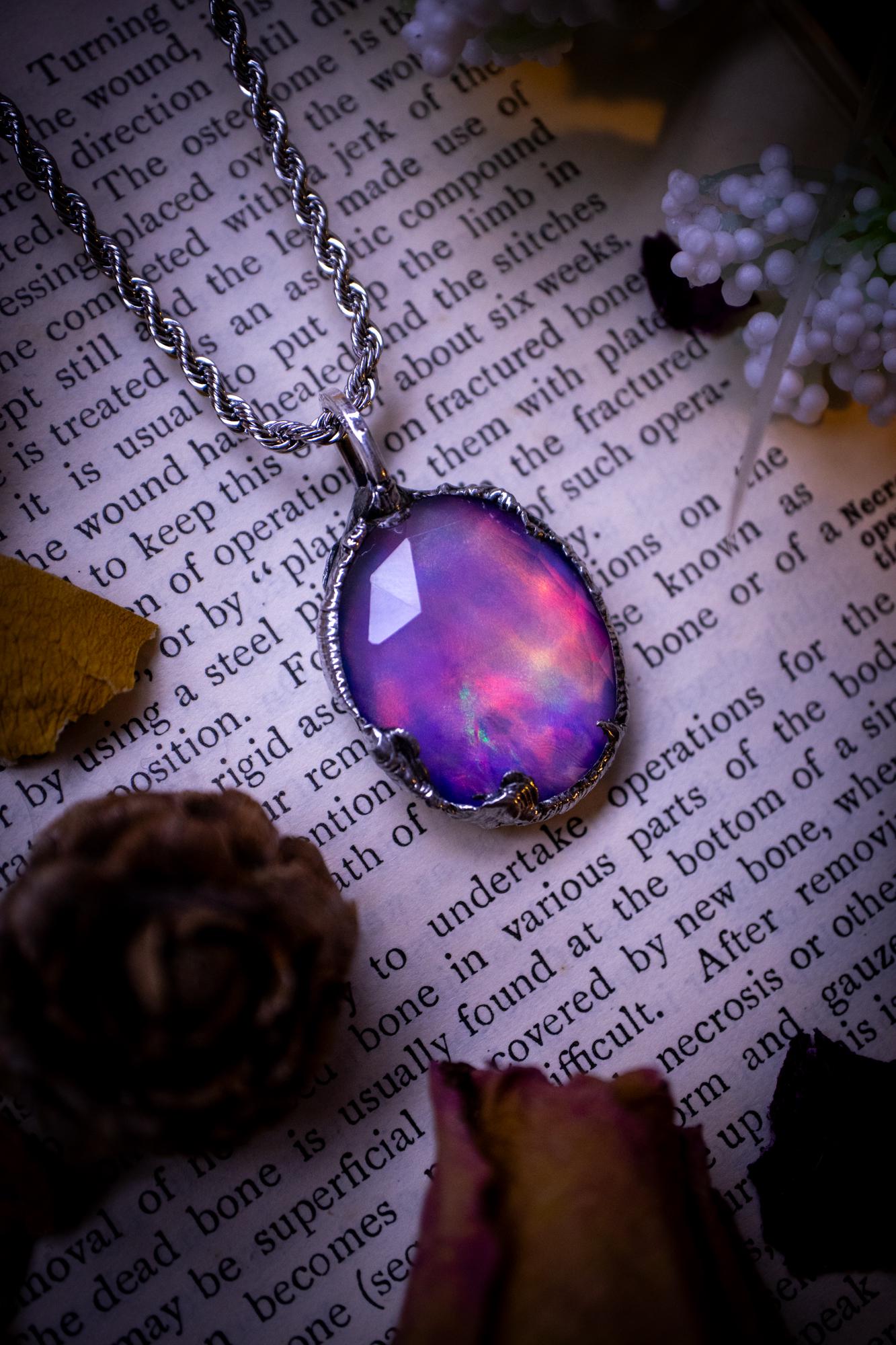 A beautiful, one of a kind, aurora opal pendant necklace. This little statement necklace is handmade using the tiffany technique, also known as soft soldering. Featuring the most stunning, and sparkly aurora opal which is full of pinks, greens and blues just like the northern lights. Aurora opals are man made opals that look similar to natural ones, they have a layer of rose quartz on top to give extra shine. The ideal gift for any crystal or jewellery lover. Gothic and witchy jewellery