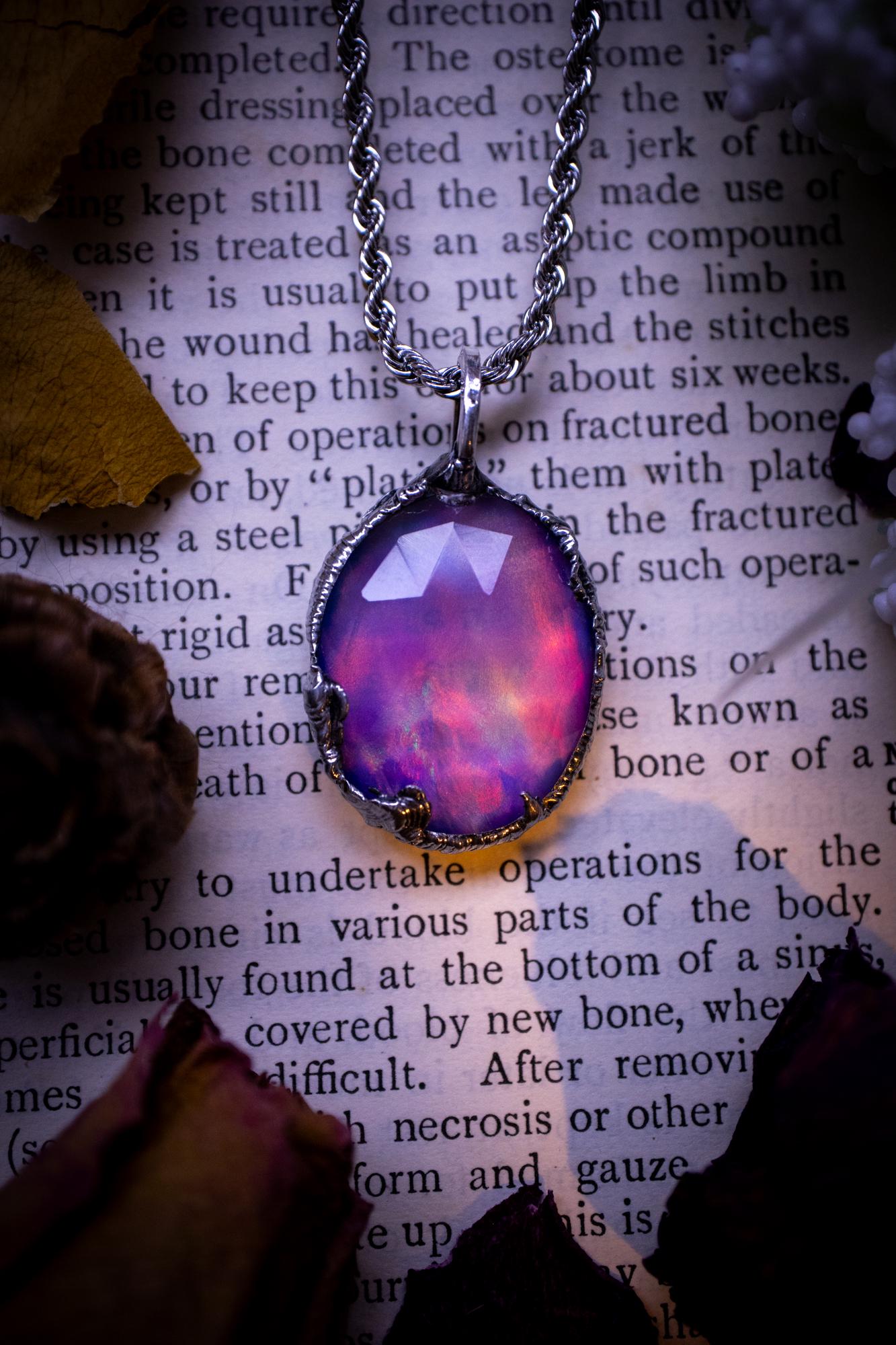 A beautiful, one of a kind, aurora opal pendant necklace. This little statement necklace is handmade using the tiffany technique, also known as soft soldering. Featuring the most stunning, and sparkly aurora opal which is full of pinks, greens and blues just like the northern lights. Aurora opals are man made opals that look similar to natural ones, they have a layer of rose quartz on top to give extra shine. The ideal gift for any crystal or jewellery lover. Gothic and witchy jewellery