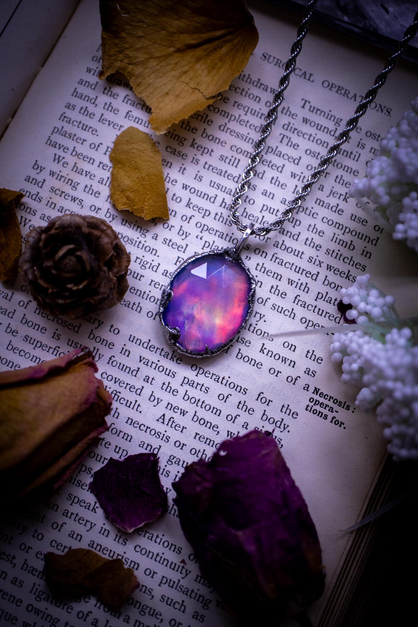 A beautiful, one of a kind, aurora opal pendant necklace. This little statement necklace is handmade using the tiffany technique, also known as soft soldering. Featuring the most stunning, and sparkly aurora opal which is full of pinks, greens and blues just like the northern lights. Aurora opals are man made opals that look similar to natural ones, they have a layer of rose quartz on top to give extra shine. The ideal gift for any crystal or jewellery lover. Gothic and witchy jewellery