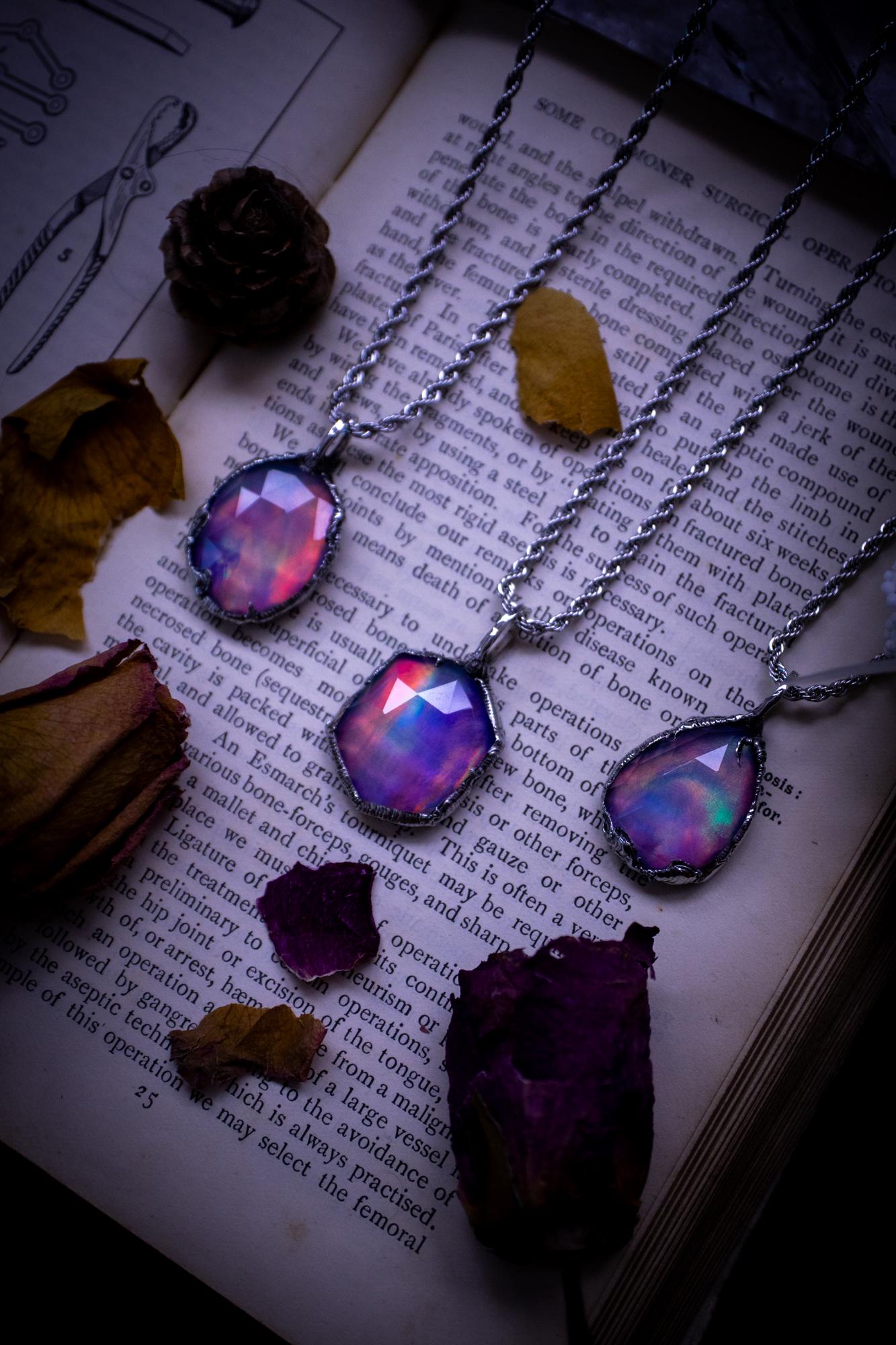 A beautiful, one of a kind, aurora opal pendant necklace. This little statement necklace is handmade using the tiffany technique, also known as soft soldering. Featuring the most stunning, and sparkly aurora opal which is full of pinks, greens and blues just like the northern lights. Aurora opals are man made opals that look similar to natural ones, they have a layer of rose quartz on top to give extra shine. The ideal gift for any crystal or jewellery lover. Gothic and witchy jewellery