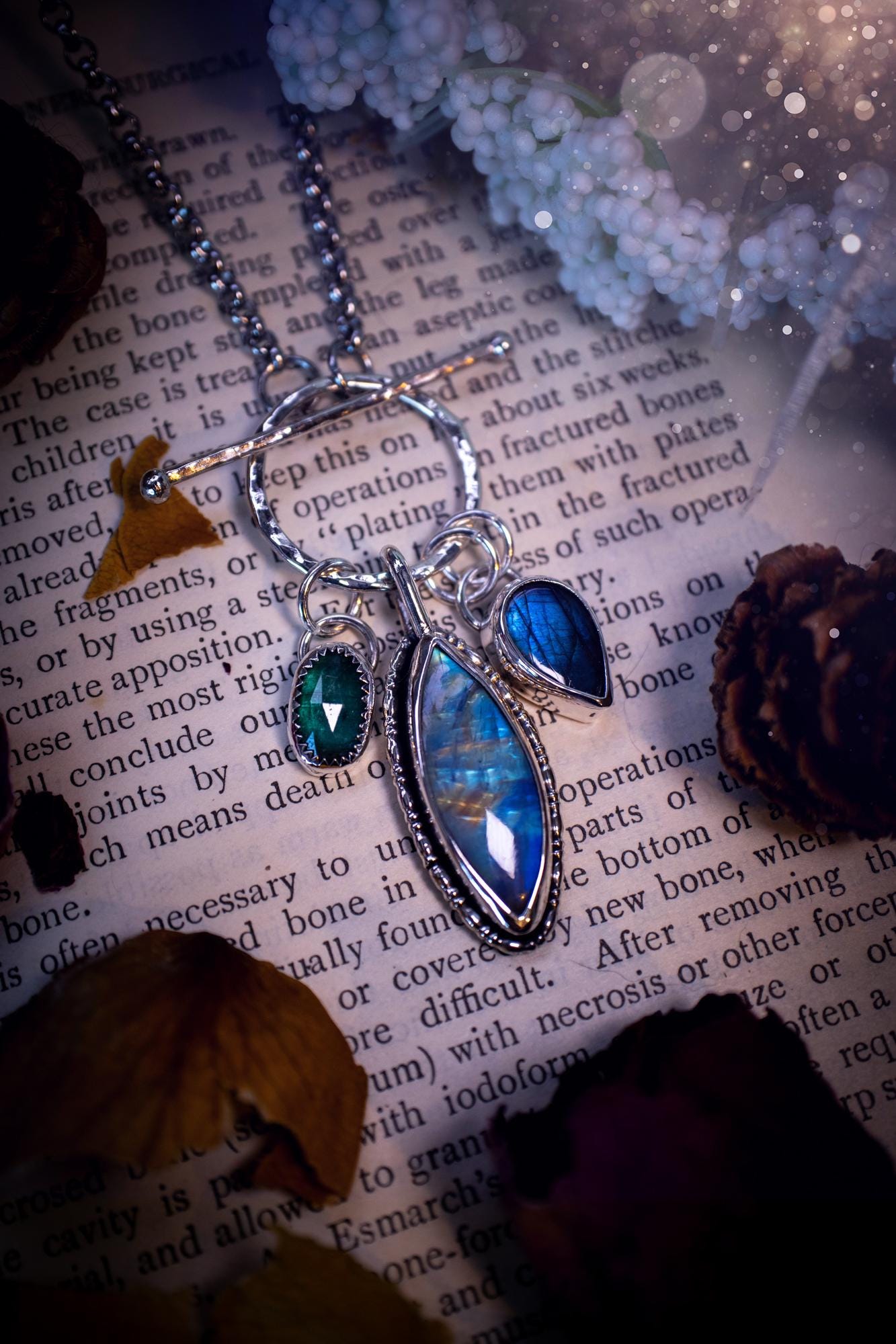 Beautiful and handmade, multi crystal charm pendant necklace. This stunning pendant necklace features a teal kyanite, a rainbow moonstone, and a purple labradorite crystal which hangs from a hammered toggle clasp. Made from a mix of fine and sterling silver, this necklace is very unique with all the beautiful crystals one could need! All crystals are natural and full of flash and vibrant colour. Ideal for any crystal or jewellery lover. Hippy, gothic and witchy jewellery.