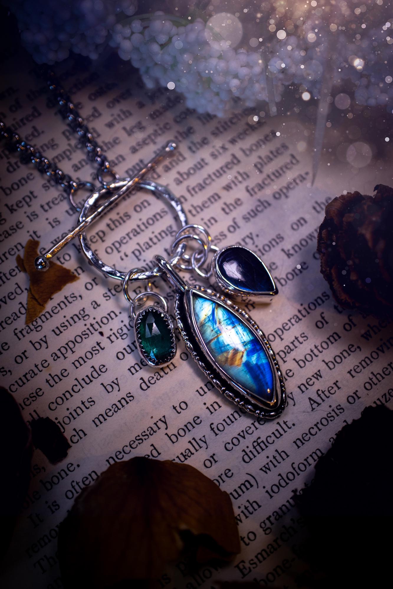 Beautiful and handmade, multi crystal charm pendant necklace. This stunning pendant necklace features a teal kyanite, a rainbow moonstone, and a purple labradorite crystal which hangs from a hammered toggle clasp. Made from a mix of fine and sterling silver, this necklace is very unique with all the beautiful crystals one could need! All crystals are natural and full of flash and vibrant colour. Ideal for any crystal or jewellery lover. Hippy, gothic and witchy jewellery.