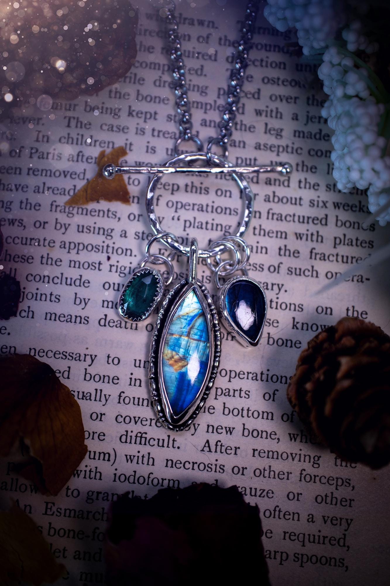Beautiful and handmade, multi crystal charm pendant necklace. This stunning pendant necklace features a teal kyanite, a rainbow moonstone, and a purple labradorite crystal which hangs from a hammered toggle clasp. Made from a mix of fine and sterling silver, this necklace is very unique with all the beautiful crystals one could need! All crystals are natural and full of flash and vibrant colour. Ideal for any crystal or jewellery lover. Hippy, gothic and witchy jewellery.
