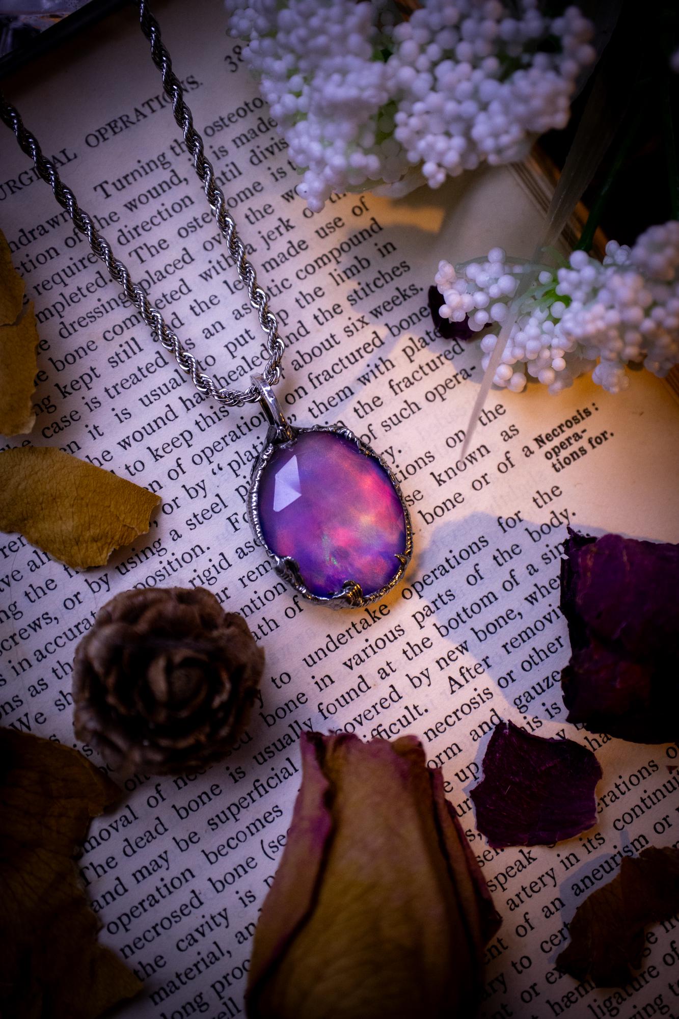 A beautiful, one of a kind, aurora opal pendant necklace. This little statement necklace is handmade using the tiffany technique, also known as soft soldering. Featuring the most stunning, and sparkly aurora opal which is full of pinks, greens and blues just like the northern lights. Aurora opals are man made opals that look similar to natural ones, they have a layer of rose quartz on top to give extra shine. The ideal gift for any crystal or jewellery lover. Gothic and witchy jewellery