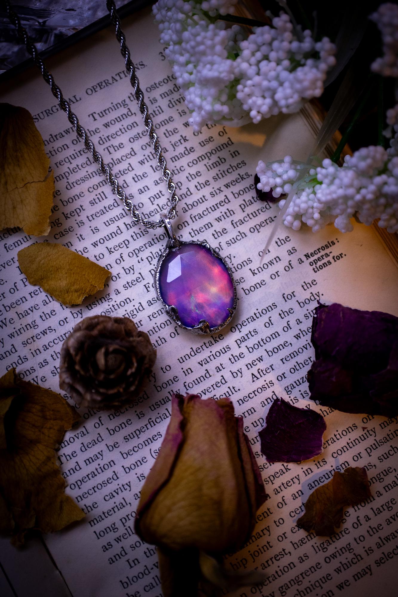 A beautiful, one of a kind, aurora opal pendant necklace. This little statement necklace is handmade using the tiffany technique, also known as soft soldering. Featuring the most stunning, and sparkly aurora opal which is full of pinks, greens and blues just like the northern lights. Aurora opals are man made opals that look similar to natural ones, they have a layer of rose quartz on top to give extra shine. The ideal gift for any crystal or jewellery lover. Gothic and witchy jewellery
