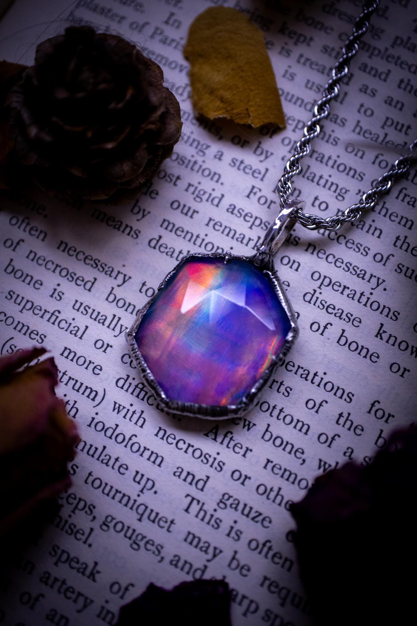 A beautiful, one of a kind, aurora opal pendant necklace. This little statement necklace is handmade using the tiffany technique, also known as soft soldering. Featuring the most stunning, and sparkly aurora opal which is full of pinks, greens and blues just like the northern lights. Aurora opals are man made opals that look similar to natural ones, they have a layer of rose quartz on top to give extra shine. The ideal gift for any crystal or jewellery lover. Gothic and witchy jewellery