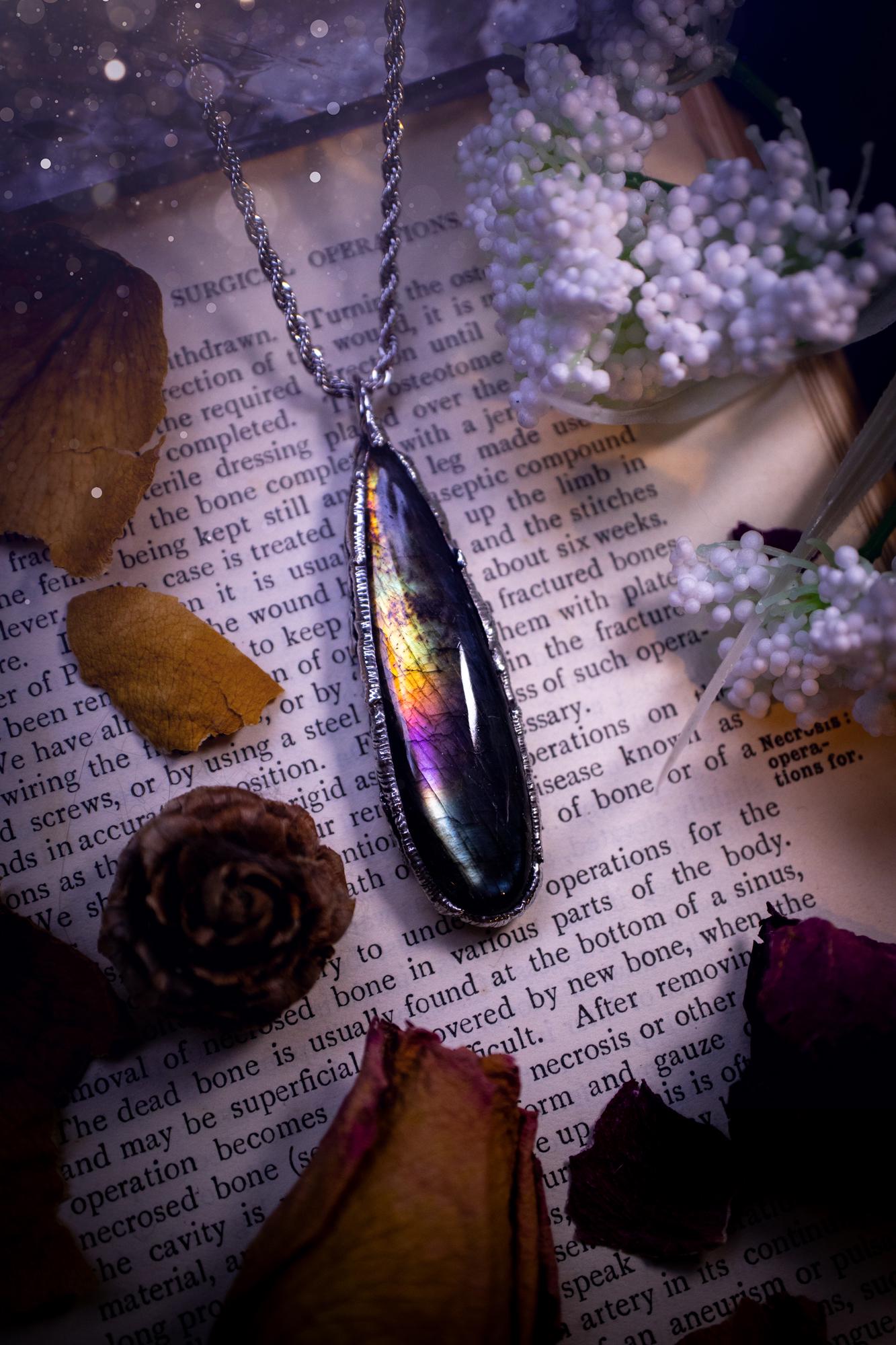 A beautiful, one of a kind, purple, green and grey multi-flash Labradorite crystal pendant necklace. This pendant has been handmade using the soft solder method, also known as the tiffany technique used to create stained glass windows. Featuring the most stunning and natural Labradorite crystal which is full of purple and green hues. The pendant is suitable for gifting to any jewellery or crystal lover, or to simply add to your own collection. One of a kind jewellery, gothic and witchy gifts