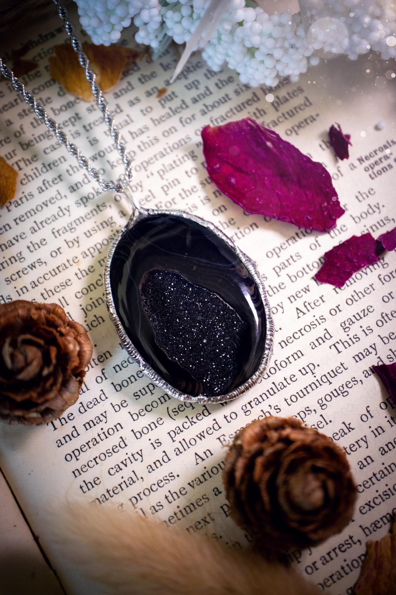 Beautiful and handcrafted, black druzy agate, crystal pendant necklace. This one of a kind piece of jewellery has been hand made using the tiffany technique, also known as soft soldering. The bezel is made with a solder that is lead free and contains elements of silver so when polished a high lustre is achieved. Featuring a large druzy agate with beautiful sparkle and banding. This is the ideal gift for any crystal or jewellery lover that likes a gothic and witchy vibe and aesthetic.