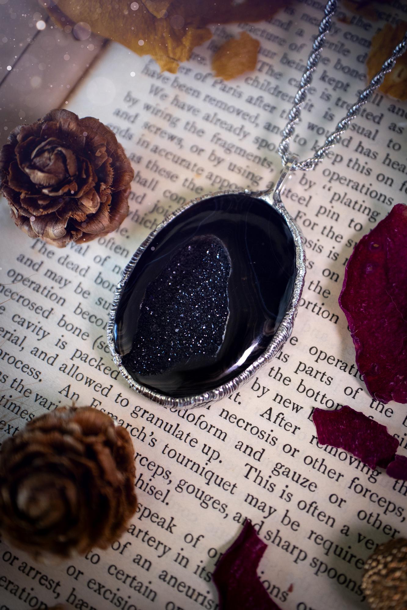 Beautiful and handcrafted, black druzy agate, crystal pendant necklace. This one of a kind piece of jewellery has been hand made using the tiffany technique, also known as soft soldering. The bezel is made with a solder that is lead free and contains elements of silver so when polished a high lustre is achieved. Featuring a large druzy agate with beautiful sparkle and banding. This is the ideal gift for any crystal or jewellery lover that likes a gothic and witchy vibe and aesthetic.