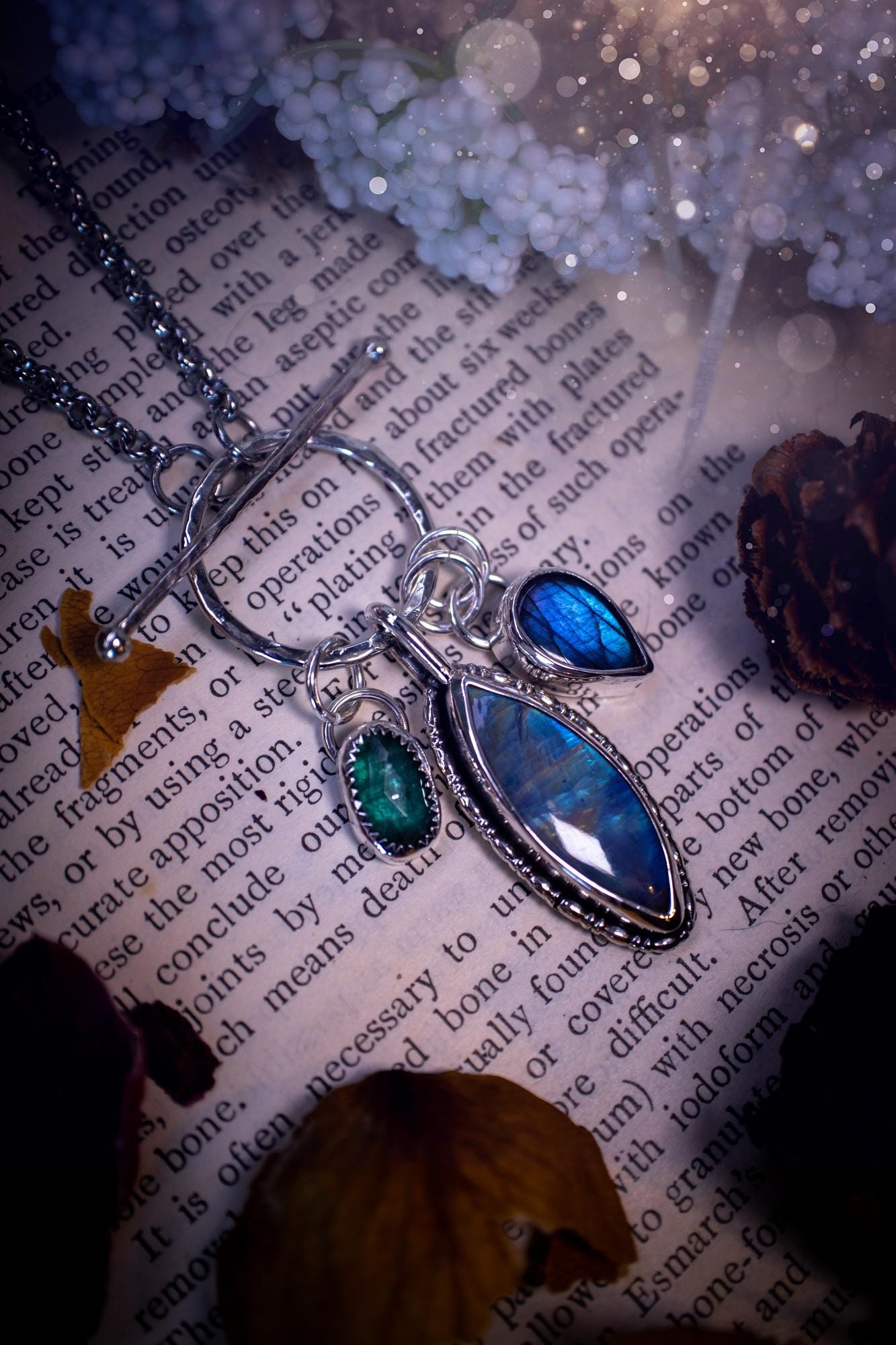 Beautiful and handmade, multi crystal charm pendant necklace. This stunning pendant necklace features a teal kyanite, a rainbow moonstone, and a purple labradorite crystal which hangs from a hammered toggle clasp. Made from a mix of fine and sterling silver, this necklace is very unique with all the beautiful crystals one could need! All crystals are natural and full of flash and vibrant colour. Ideal for any crystal or jewellery lover. Hippy, gothic and witchy jewellery.