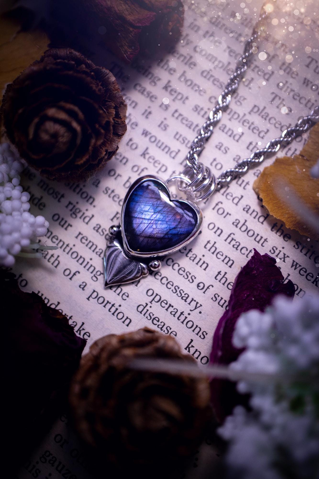 Stunning and handmade, all natural, purple and blue, labradorite crystal heart pendant necklace. This pendant necklace has been handmade from fine and sterling silver. Featuring the most beautiful labradorite heart crystal that is full of bold purples, deep blues and a shimmer of silver. Accompanying the crystal gemstone is fan and ball silver components giving this piece its own uniqueness. This piece of jewellery would be ideal for any crystal or jewellery lover and gives off gothic vibes.