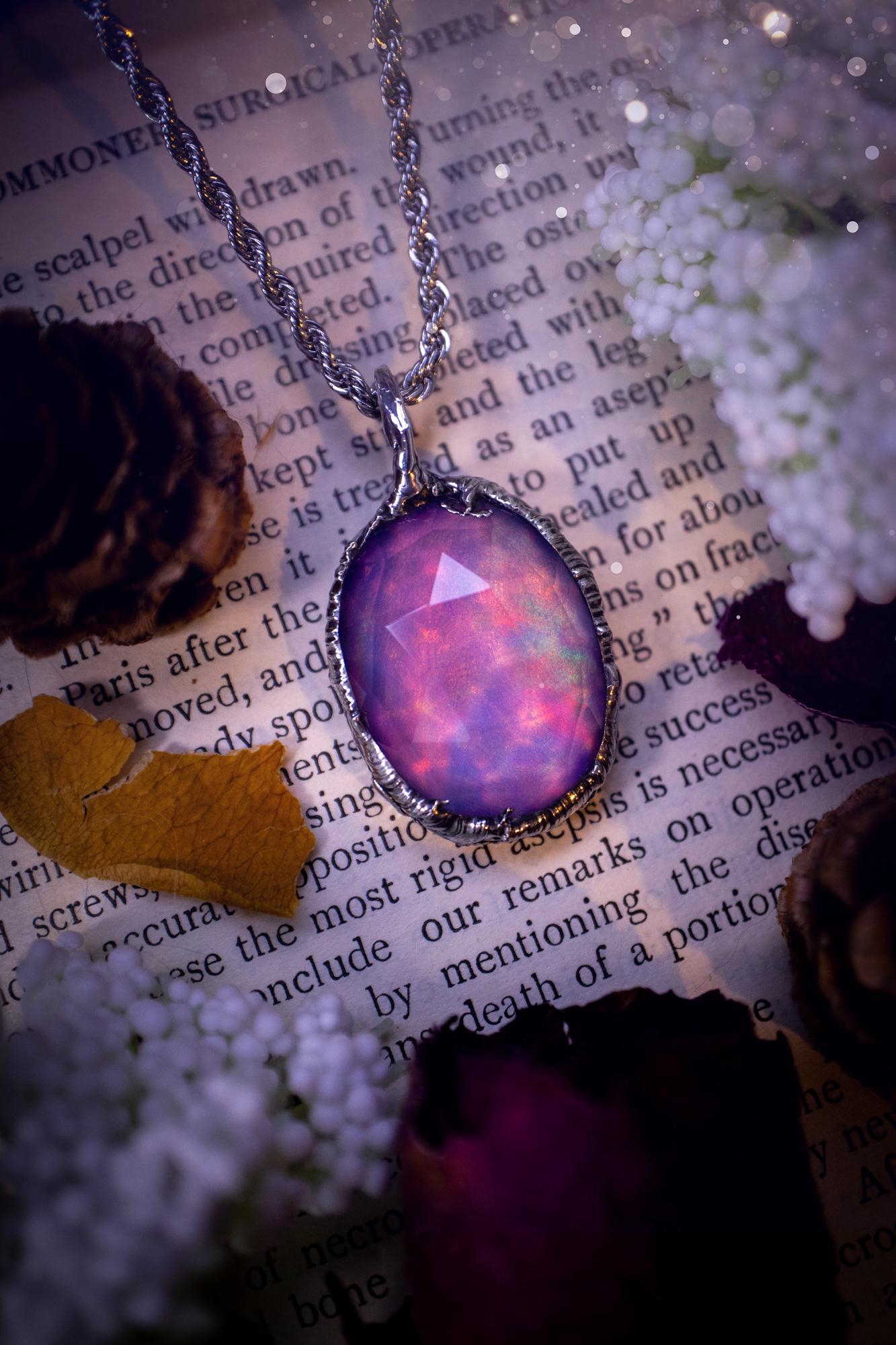 A beautiful, one of a kind, aurora opal pendant necklace. This little statement necklace is handmade using the tiffany technique, also known as soft soldering. Featuring the most stunning, and sparkly aurora opal which is full of pinks, greens and blues just like the northern lights. Aurora opals are man made opals that look similar to natural ones, they have a layer of rose quartz on top to give extra shine. The ideal gift for any crystal or jewellery lover. Gothic and witchy jewellery
