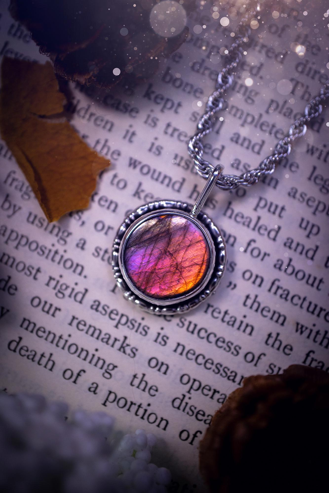 Dainty but beautiful, handcrafted, natural pink, purple, and silver labradorite spectrolite pendant necklace. This beautiful pendant has been handmade using recycled fine and sterling silver. Featuring a round labradorite that is full of natural pinks, purples and silver hues. Around the crystal is a smooth inner bezel with gallery wire around as the outer bezel. This is the ideal piece of jewellery for a loved one or to treat yourself. Suitable for crystal and jewellery lovers. Gothic vibes.