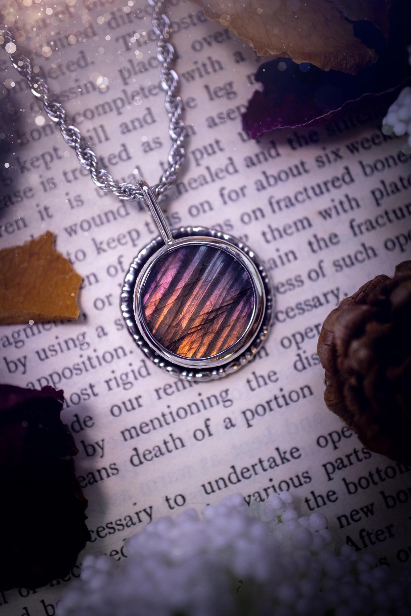Beautiful and handcrafted, natural rainbow, pink, purple, and silver labradorite spectrolite pendant necklace. This beautiful pendant has been handmade using recycled fine and sterling silver. Featuring a round labradorite that is full of natural pinks, purples and silver hues. Around the crystal is a smooth inner bezel with gallery wire around as the outer bezel. This is the ideal piece of jewellery for a loved one or to treat yourself. Suitable for crystal and jewellery lovers. Gothic vibes.