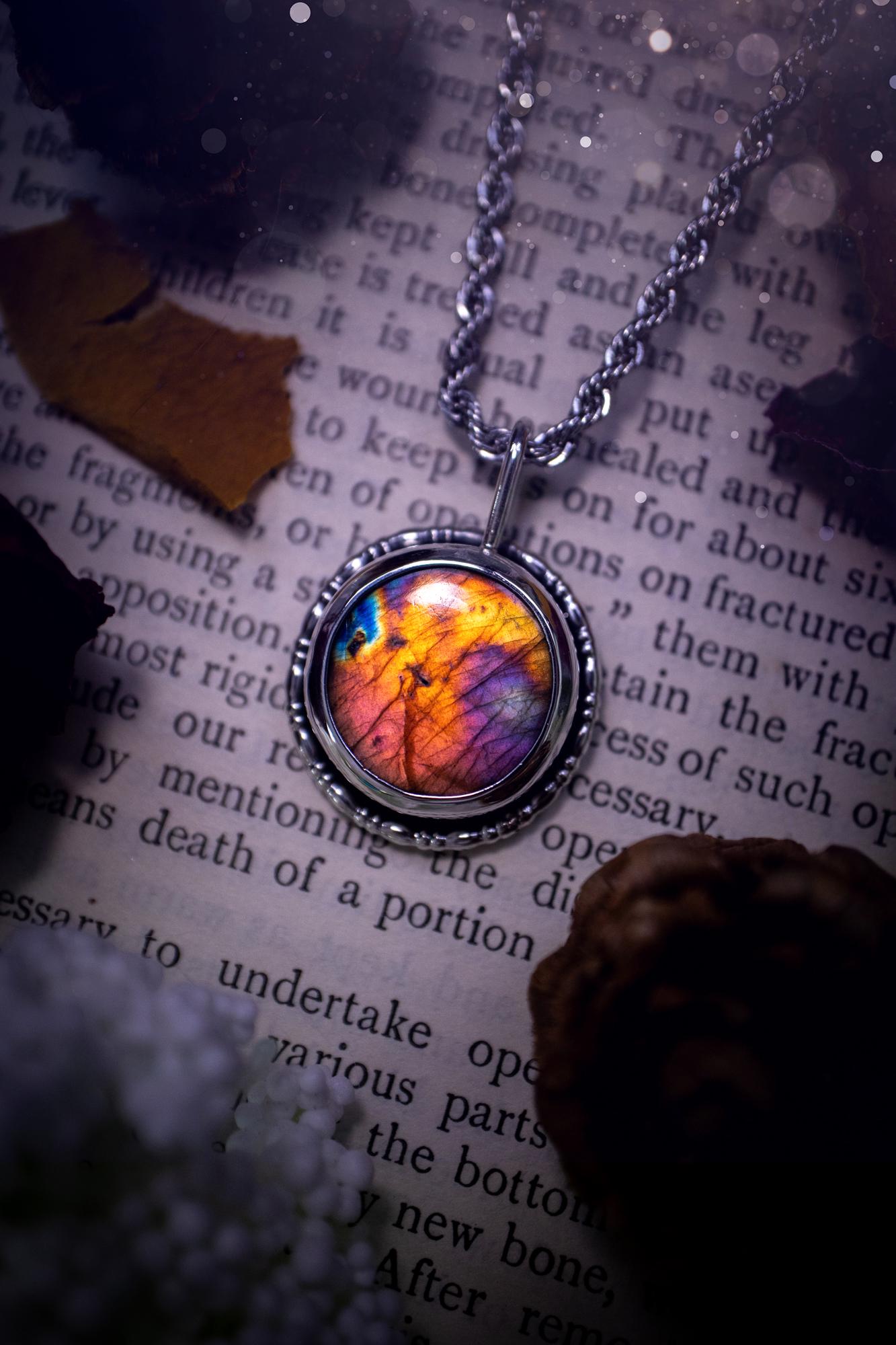 Beautiful and handcrafted, natural rainbow, pink, purple, and orange labradorite spectrolite pendant necklace. This beautiful pendant has been handmade using recycled fine and sterling silver. Featuring a round labradorite that is full of natural pinks, purples and orange hues. Around the crystal is a smooth inner bezel with gallery wire around as the outer bezel. This is the ideal piece of jewellery for a loved one or to treat yourself. Suitable for crystal and jewellery lovers. Gothic vibes.