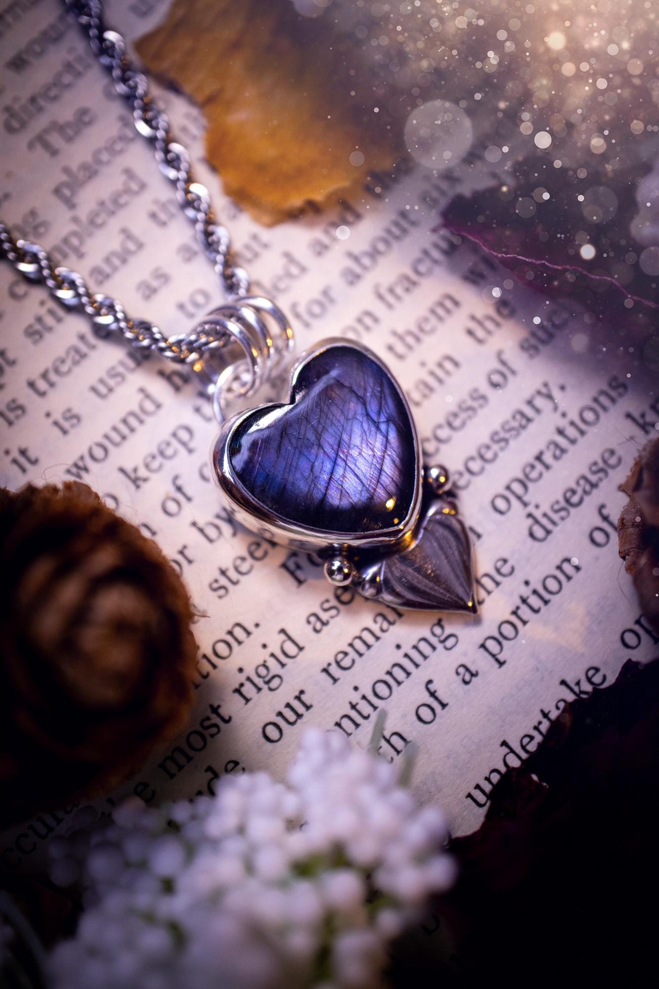 Stunning and handmade, all natural, purple and blue, labradorite crystal heart pendant necklace. This pendant necklace has been handmade from fine and sterling silver. Featuring the most beautiful labradorite heart crystal that is full of bold purples, deep blues and a shimmer of silver. Accompanying the crystal gemstone is fan and ball silver components giving this piece its own uniqueness. This piece of jewellery would be ideal for any crystal or jewellery lover and gives off gothic vibes.