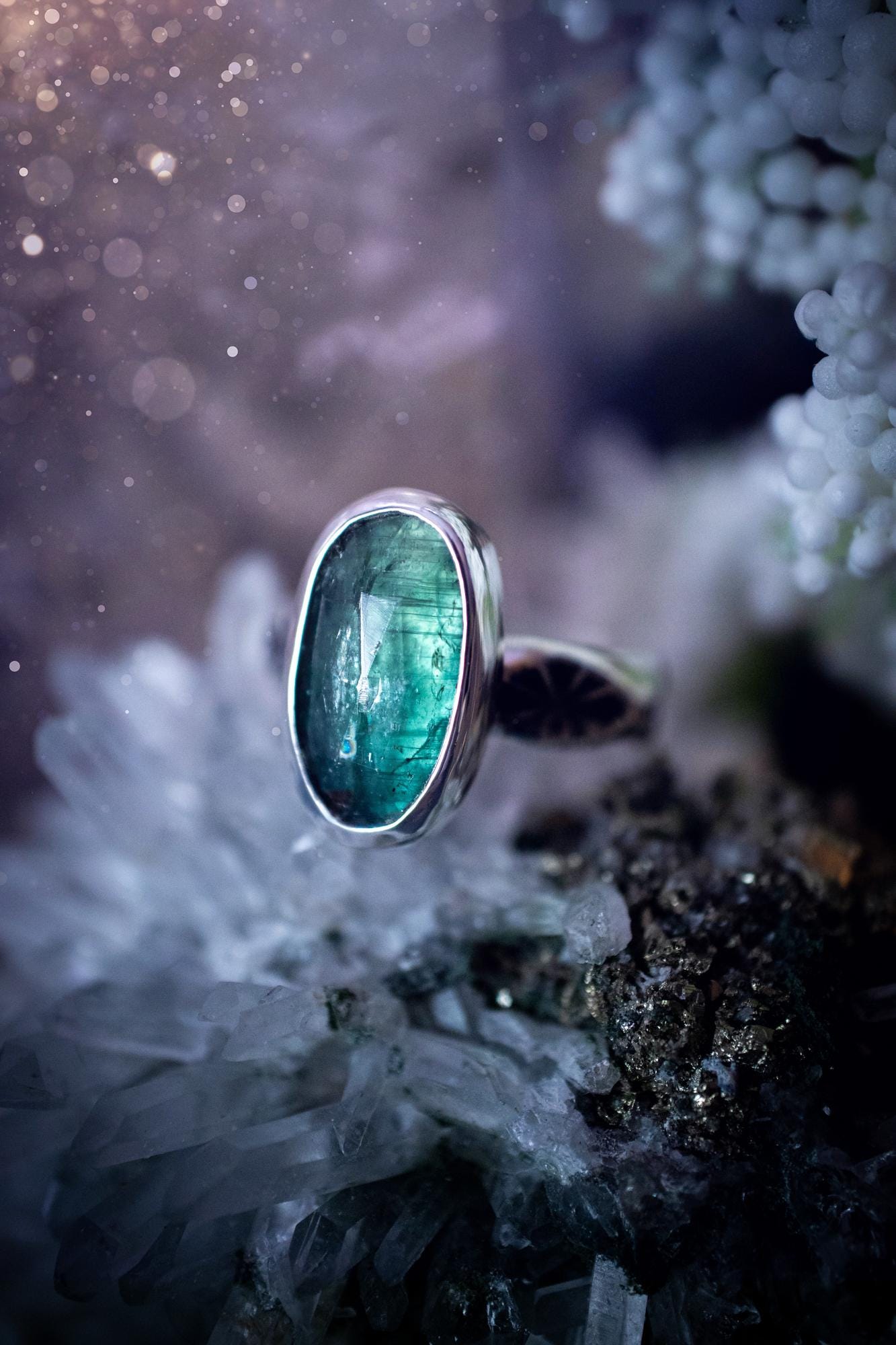 Beautiful and handcrafted, natural teal green kyanite crystal, staking ring. This stunning ring has been hand made using fine and sterling silver. It features a beautiful and natural teal green kyanite crystal that has rainbows and flash, such a gorgeous colour. The ring shank on this ring has been stamped with a gothic pattern to give it a one of a kind vibe. Ideal gift for that special person in your life, or for any crystal and jewellery lover. Hippy, witchy and gothic jewellery for the soul.