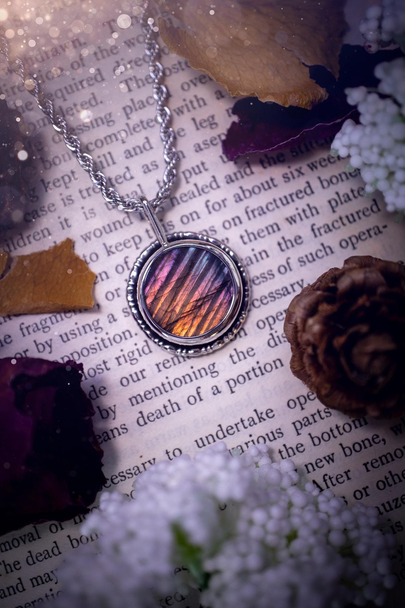 Beautiful and handcrafted, natural rainbow, pink, purple, and silver labradorite spectrolite pendant necklace. This beautiful pendant has been handmade using recycled fine and sterling silver. Featuring a round labradorite that is full of natural pinks, purples and silver hues. Around the crystal is a smooth inner bezel with gallery wire around as the outer bezel. This is the ideal piece of jewellery for a loved one or to treat yourself. Suitable for crystal and jewellery lovers. Gothic vibes.