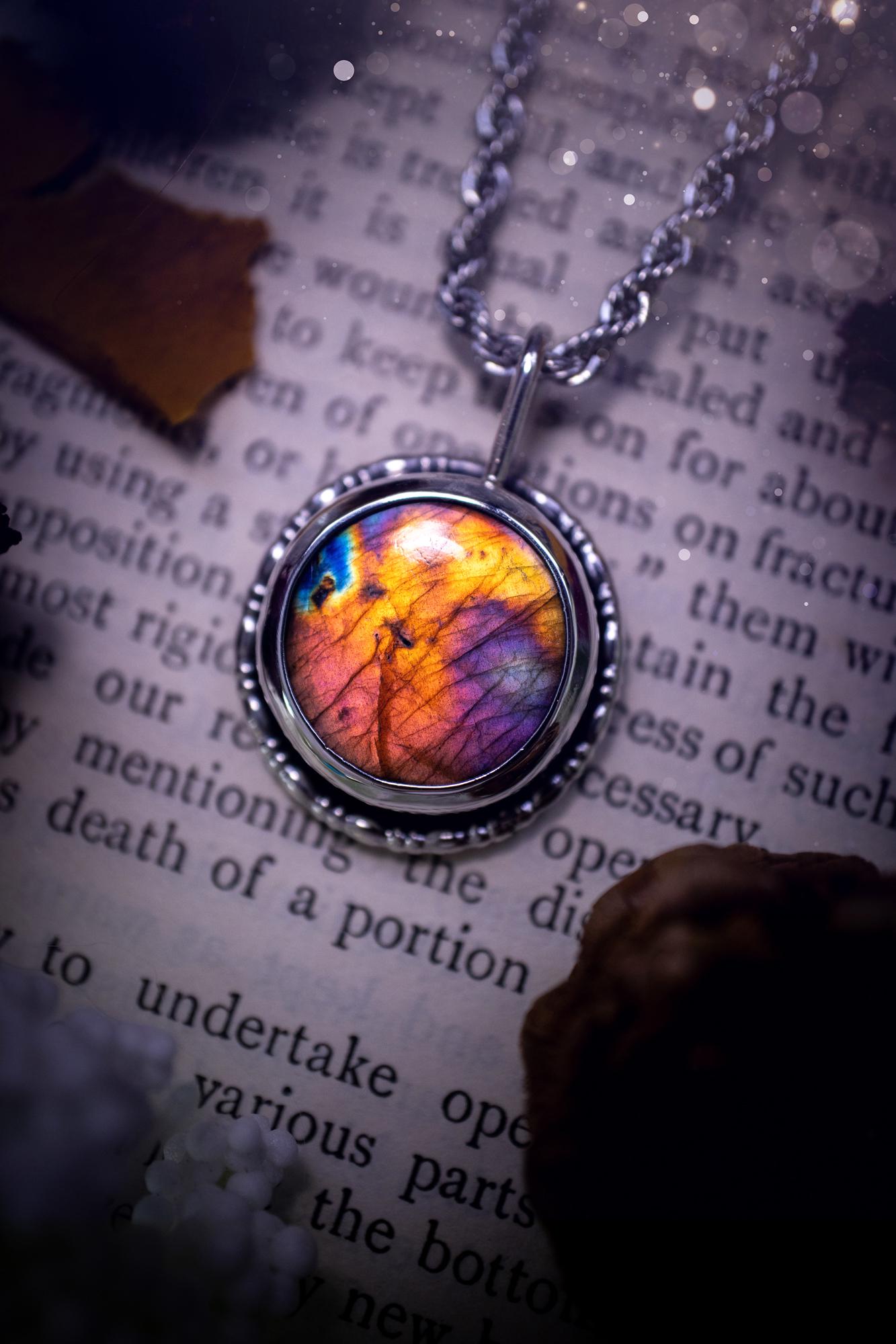 Beautiful and handcrafted, natural rainbow, pink, purple, and orange labradorite spectrolite pendant necklace. This beautiful pendant has been handmade using recycled fine and sterling silver. Featuring a round labradorite that is full of natural pinks, purples and orange hues. Around the crystal is a smooth inner bezel with gallery wire around as the outer bezel. This is the ideal piece of jewellery for a loved one or to treat yourself. Suitable for crystal and jewellery lovers. Gothic vibes.