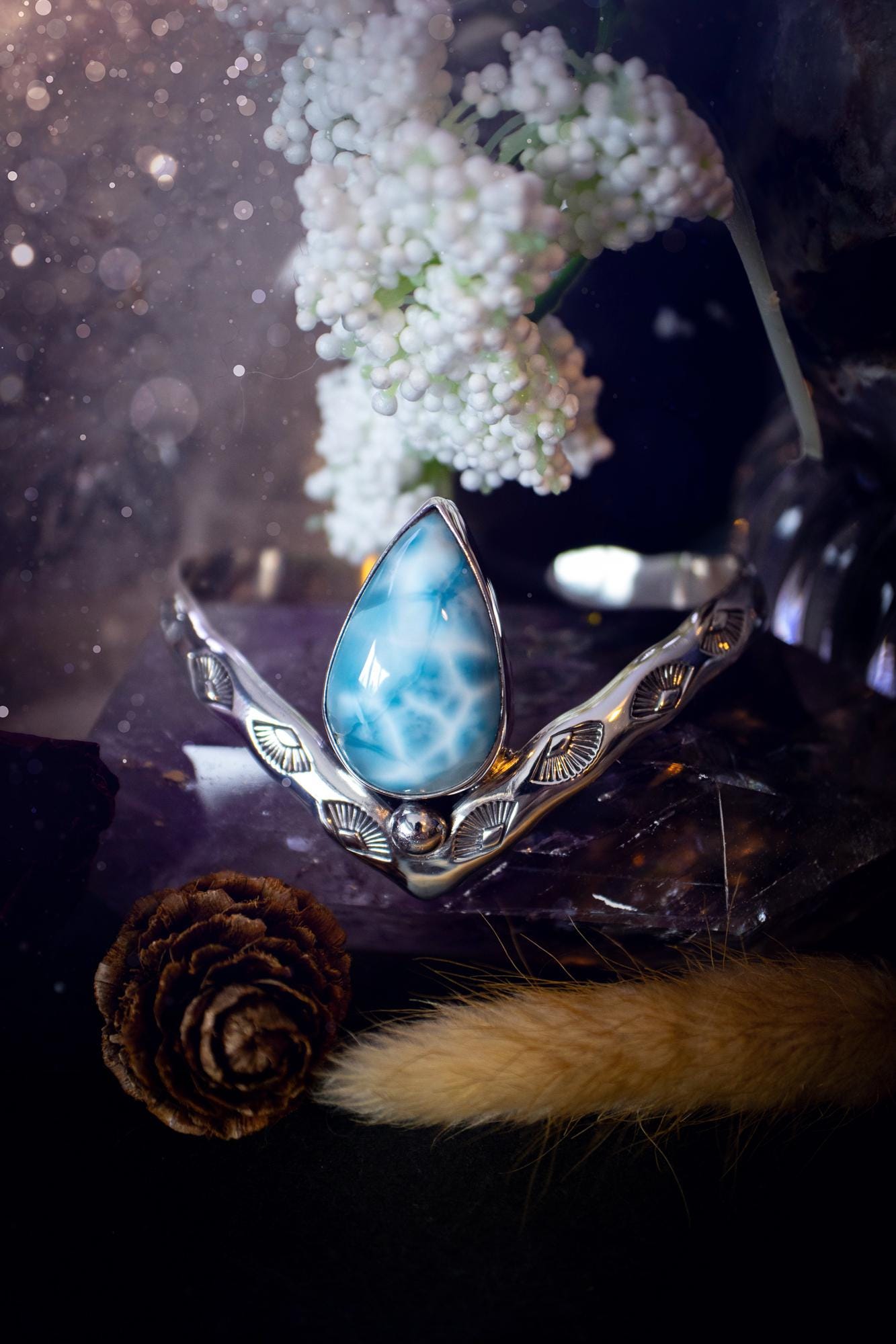 Beautifully handmade, statement larimar crystal, sterling silver cuff bracelet. This bracelet features the most stunning, high grade larimar crystal gemstone at the focal point of this wishbone cuff. Made from a mix of fine and sterling silver with stamped detail, and ball component to give the bracelet its uniqueness! A beautiful piece of jewellery that is ideal for any crystal or jewellery lover! The piece is full of hippy and beach vibes and would look lovely with any summer outfit!