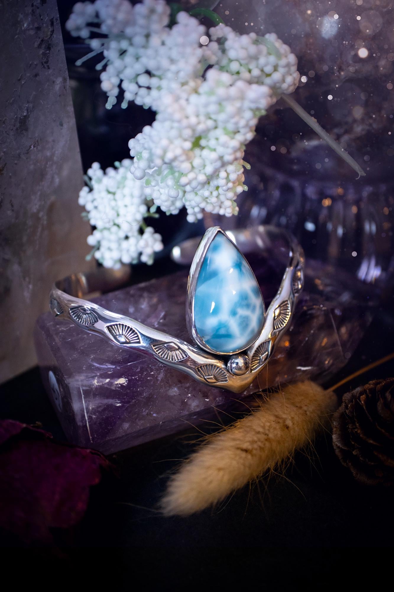 Beautifully handmade, statement larimar crystal, sterling silver cuff bracelet. This bracelet features the most stunning, high grade larimar crystal gemstone at the focal point of this wishbone cuff. Made from a mix of fine and sterling silver with stamped detail, and ball component to give the bracelet its uniqueness! A beautiful piece of jewellery that is ideal for any crystal or jewellery lover! The piece is full of hippy and beach vibes and would look lovely with any summer outfit!