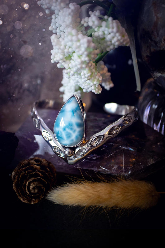 Beautifully handmade, statement larimar crystal, sterling silver cuff bracelet. This bracelet features the most stunning, high grade larimar crystal gemstone at the focal point of this wishbone cuff. Made from a mix of fine and sterling silver with stamped detail, and ball component to give the bracelet its uniqueness! A beautiful piece of jewellery that is ideal for any crystal or jewellery lover! The piece is full of hippy and beach vibes and would look lovely with any summer outfit!