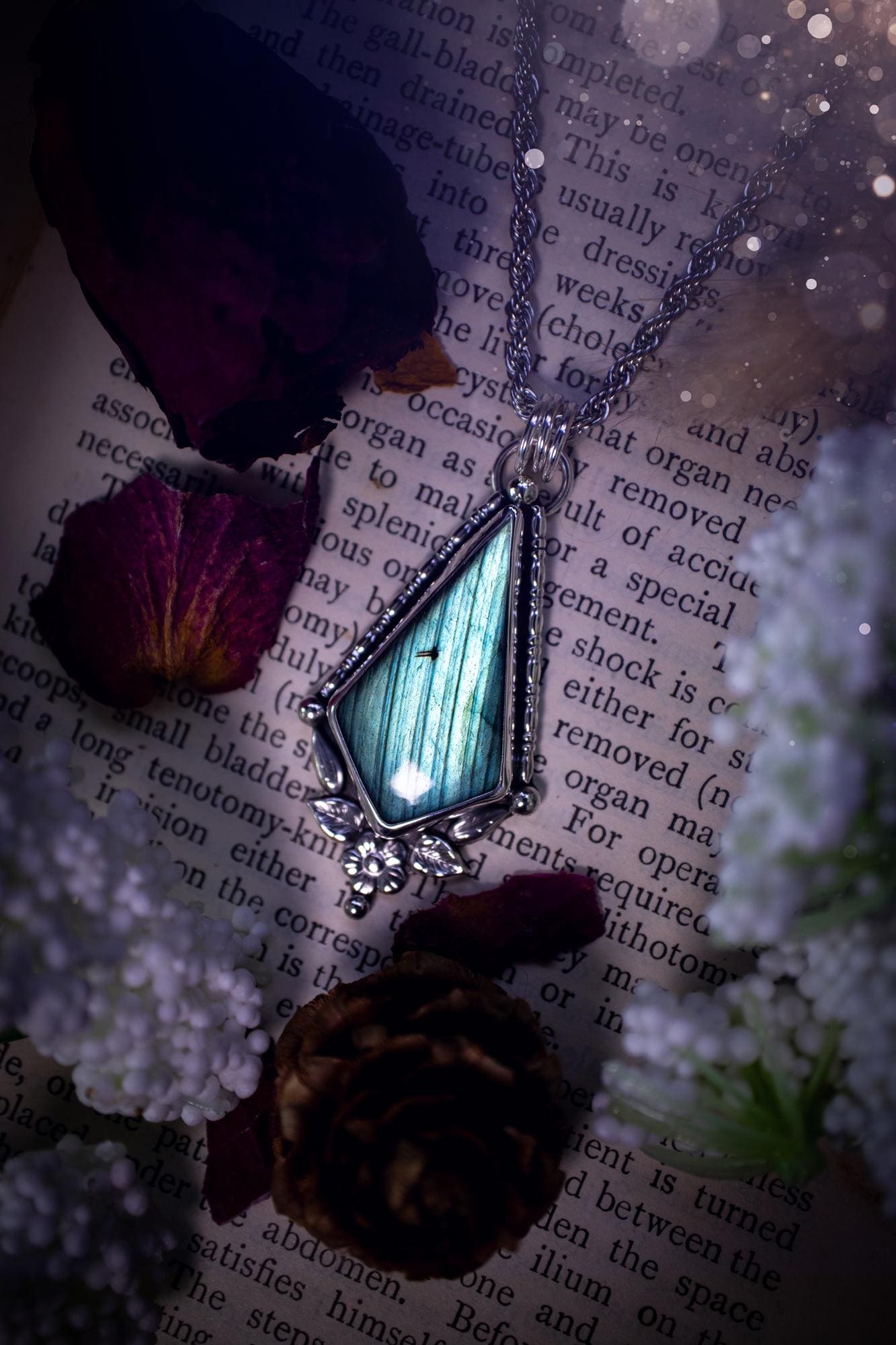 This stunning pendant necklace has been handcrafted using a mix of recycled fine and sterling silver. Featuring a beautiful and natural green and blue hued labradorite crystal that is full of flash! accompanying this magical crystal is a mix of fae inspired components such as little leaves, flower, silver balls and gothic gallery wire. A true bespoke piece with no other being the same! Ideal for any crystal and jewellery lover that loves a witchy and gothic vibe, along with the beauty of nature!