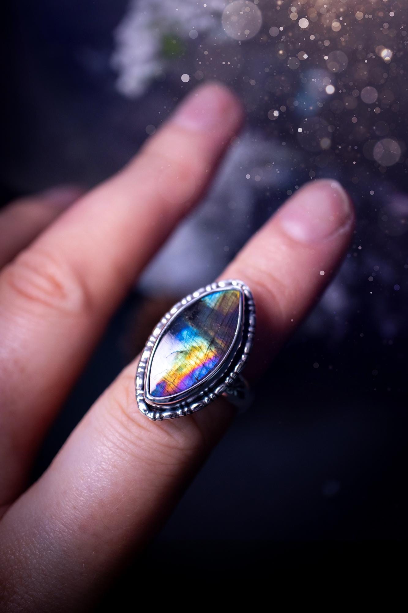 Handcrafted sterling silver statement ring featuring a stunning spectrolite labradorite crystal with vibrant flashes of purple, yellow, and blue. This magical gemstone shimmers with an ethereal glow, making it a captivating piece for any jewellery collection. Ideal for crystal lovers, spiritual souls, and those drawn to unique, one-of-a-kind designs. A bold, mystical accessory perfect for expressing your inner light and energy. Gothic and handmade jewellery gifts, ideal for crystal lovers.