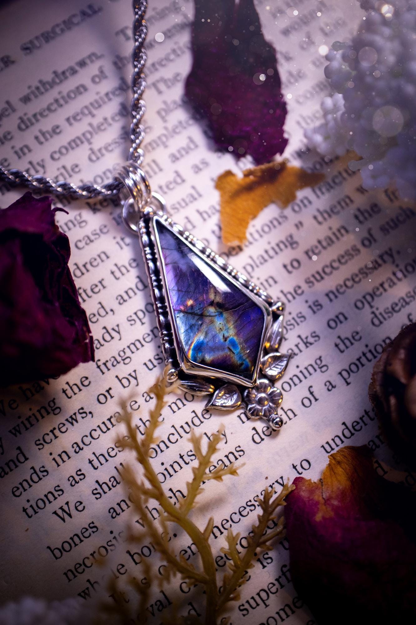 This stunning pendant necklace has been handcrafted using a mix of recycled fine and sterling silver. Featuring a beautiful and natural purple and pink hued labradorite crystal that is full of flash! accompanying this magical crystal is a mix of fae inspired components such as little leaves, flower, silver balls and gothic gallery wire. A true bespoke piece with no other being the same! Ideal for any crystal and jewellery lover that loves a witchy and gothic vibe, along with the beauty of nature