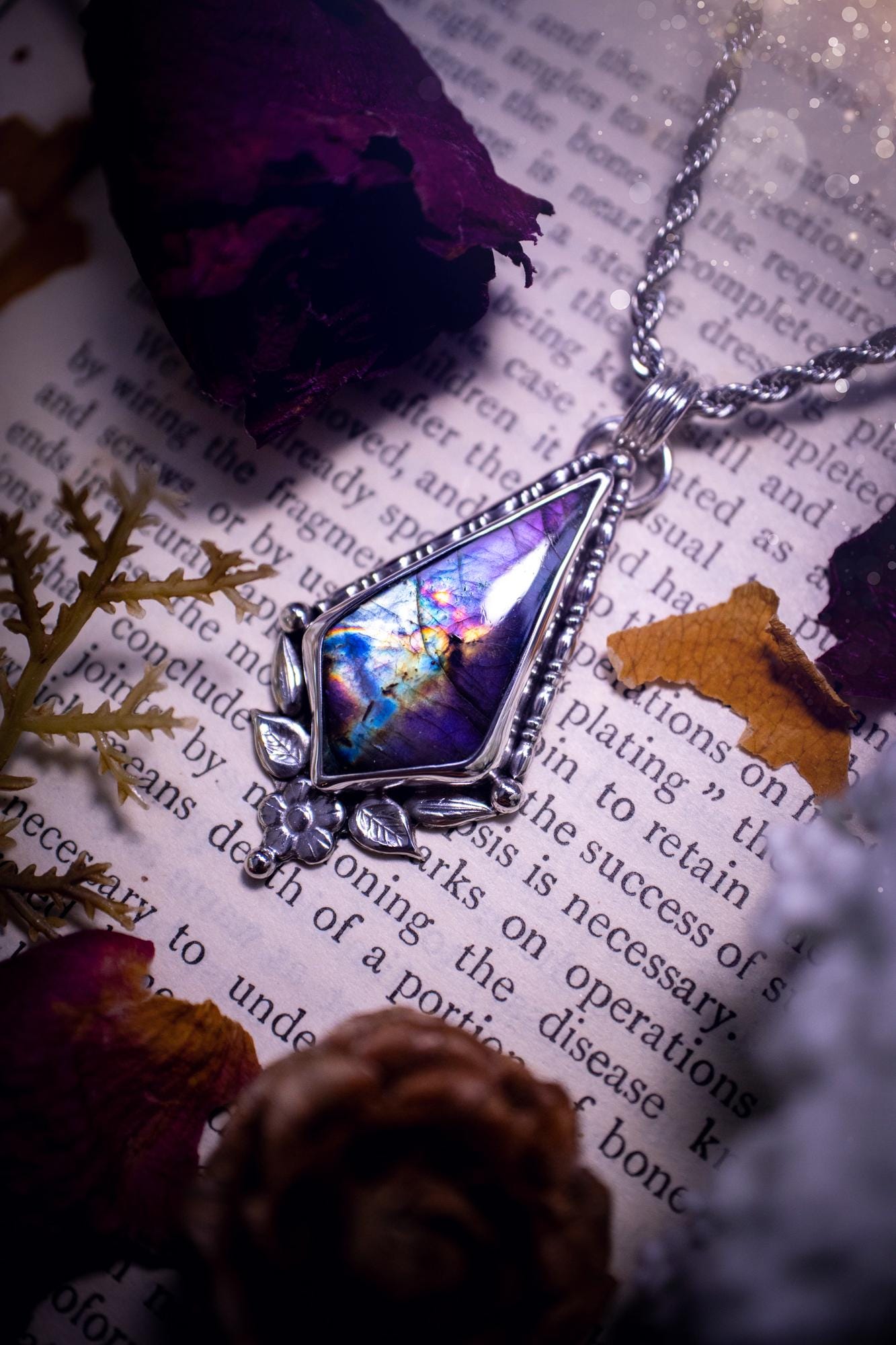 This stunning pendant necklace has been handcrafted using a mix of recycled fine and sterling silver. Featuring a beautiful and natural purple and pink hued labradorite crystal that is full of flash! accompanying this magical crystal is a mix of fae inspired components such as little leaves, flower, silver balls and gothic gallery wire. A true bespoke piece with no other being the same! Ideal for any crystal and jewellery lover that loves a witchy and gothic vibe, along with the beauty of nature
