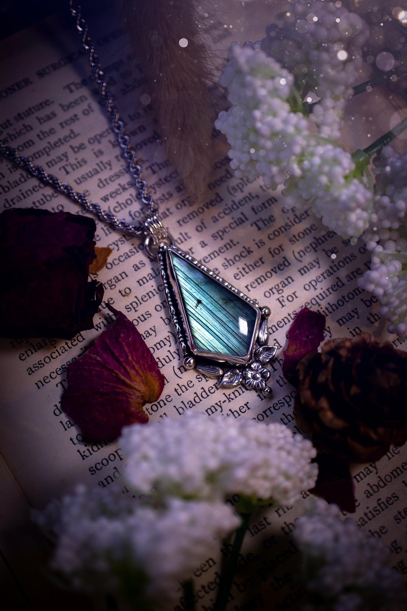This stunning pendant necklace has been handcrafted using a mix of recycled fine and sterling silver. Featuring a beautiful and natural green and blue hued labradorite crystal that is full of flash! accompanying this magical crystal is a mix of fae inspired components such as little leaves, flower, silver balls and gothic gallery wire. A true bespoke piece with no other being the same! Ideal for any crystal and jewellery lover that loves a witchy and gothic vibe, along with the beauty of nature!