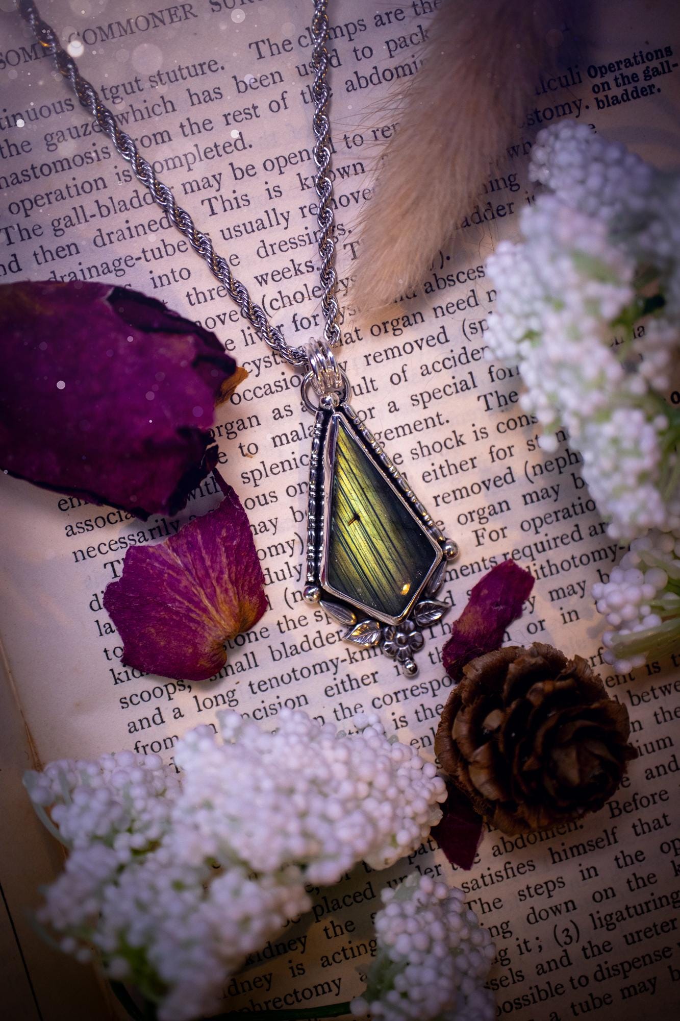 This stunning pendant necklace has been handcrafted using a mix of recycled fine and sterling silver. Featuring a beautiful and natural green and blue hued labradorite crystal that is full of flash! accompanying this magical crystal is a mix of fae inspired components such as little leaves, flower, silver balls and gothic gallery wire. A true bespoke piece with no other being the same! Ideal for any crystal and jewellery lover that loves a witchy and gothic vibe, along with the beauty of nature!