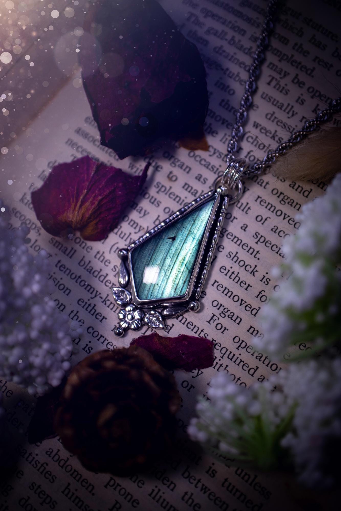 This stunning pendant necklace has been handcrafted using a mix of recycled fine and sterling silver. Featuring a beautiful and natural green and blue hued labradorite crystal that is full of flash! accompanying this magical crystal is a mix of fae inspired components such as little leaves, flower, silver balls and gothic gallery wire. A true bespoke piece with no other being the same! Ideal for any crystal and jewellery lover that loves a witchy and gothic vibe, along with the beauty of nature!