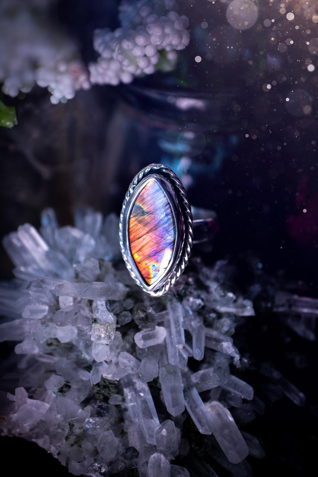 Handcrafted sterling silver statement ring featuring a stunning spectrolite labradorite crystal with vibrant flashes of purple, pink, and orange. This magical gemstone shimmers with an ethereal glow, making it a captivating piece for any jewellery collection. Ideal for crystal lovers, spiritual souls, and those drawn to unique, one-of-a-kind designs. A bold, mystical accessory perfect for expressing your inner light and energy. Gothic and handmade jewellery gifts, ideal for crystal lovers.