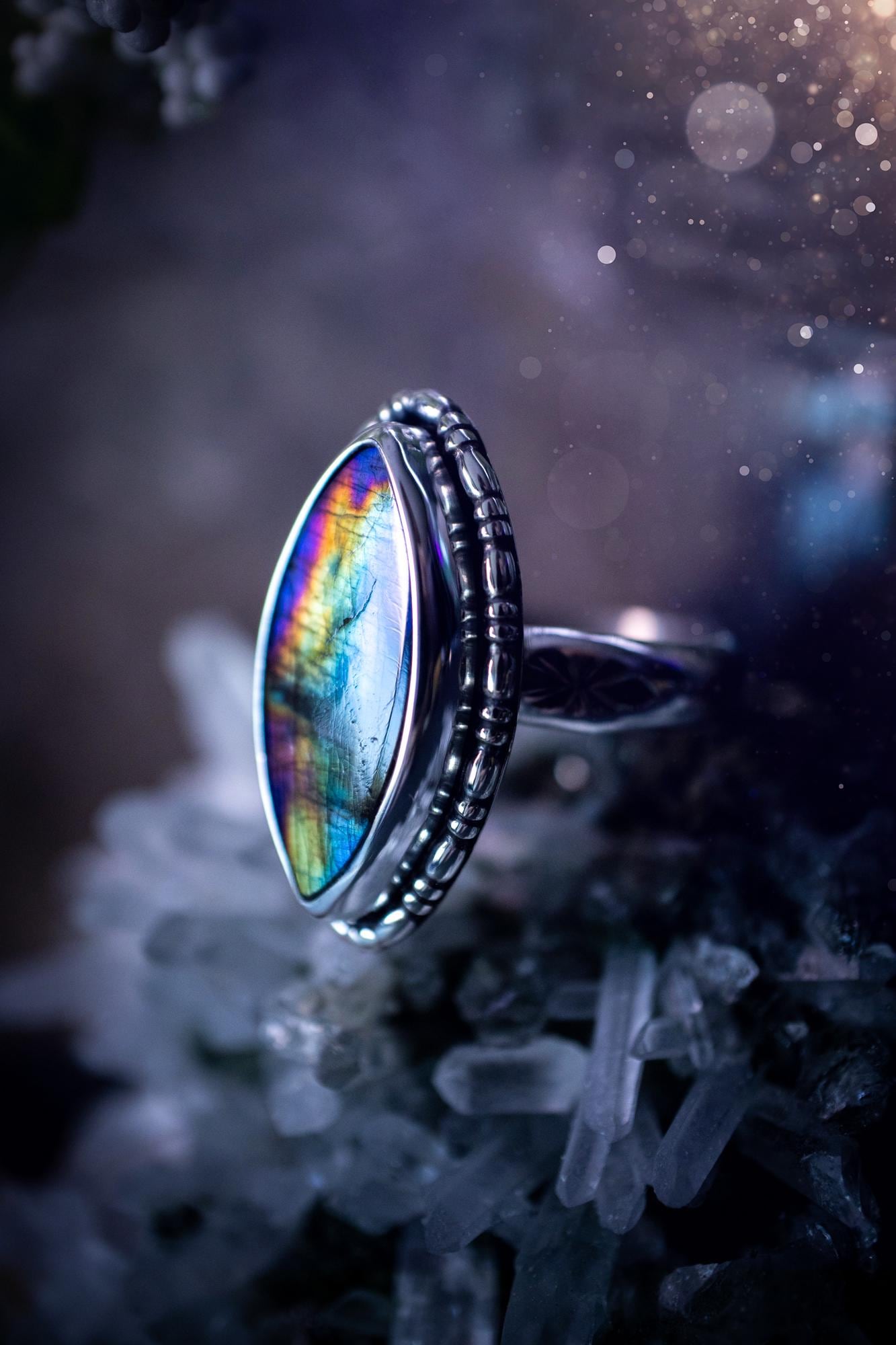 Handcrafted sterling silver statement ring featuring a stunning spectrolite labradorite crystal with vibrant flashes of purple, yellow, and blue. This magical gemstone shimmers with an ethereal glow, making it a captivating piece for any jewellery collection. Ideal for crystal lovers, spiritual souls, and those drawn to unique, one-of-a-kind designs. A bold, mystical accessory perfect for expressing your inner light and energy. Gothic and handmade jewellery gifts, ideal for crystal lovers.
