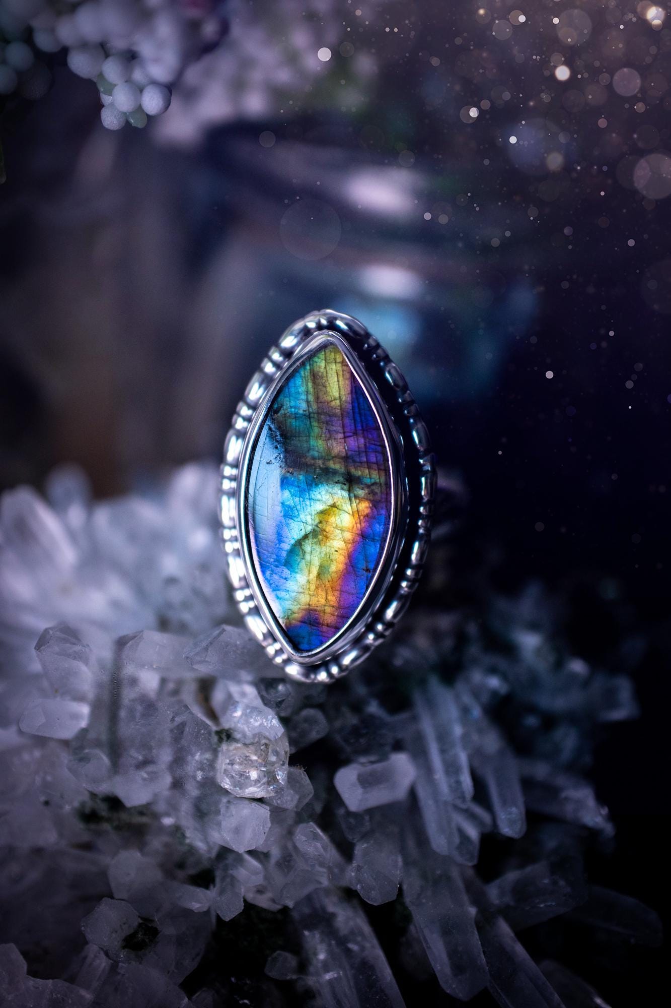 Handcrafted sterling silver statement ring featuring a stunning spectrolite labradorite crystal with vibrant flashes of purple, yellow, and blue. This magical gemstone shimmers with an ethereal glow, making it a captivating piece for any jewellery collection. Ideal for crystal lovers, spiritual souls, and those drawn to unique, one-of-a-kind designs. A bold, mystical accessory perfect for expressing your inner light and energy. Gothic and handmade jewellery gifts, ideal for crystal lovers.