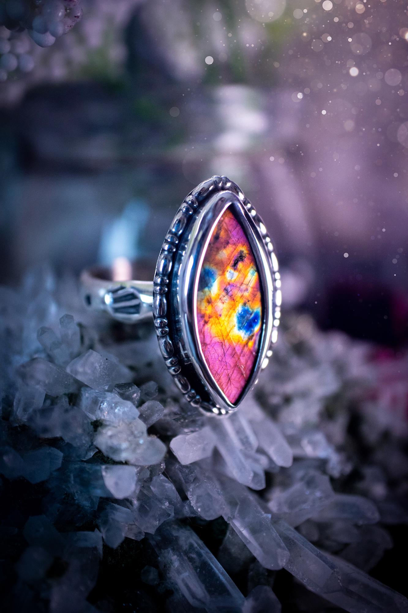 Handcrafted sterling silver statement ring featuring a stunning spectrolite labradorite crystal with vibrant flashes of purple, pink, and orange. This magical gemstone shimmers with an ethereal glow, making it a captivating piece for any jewellery collection. Ideal for crystal lovers, spiritual souls, and those drawn to unique, one-of-a-kind designs. A bold, mystical accessory perfect for expressing your inner light and energy. Gothic and handmade jewellery gifts, ideal for crystal lovers.