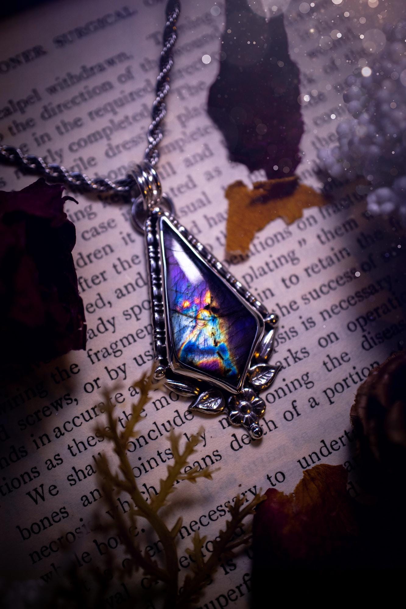 This stunning pendant necklace has been handcrafted using a mix of recycled fine and sterling silver. Featuring a beautiful and natural purple and pink hued labradorite crystal that is full of flash! accompanying this magical crystal is a mix of fae inspired components such as little leaves, flower, silver balls and gothic gallery wire. A true bespoke piece with no other being the same! Ideal for any crystal and jewellery lover that loves a witchy and gothic vibe, along with the beauty of nature