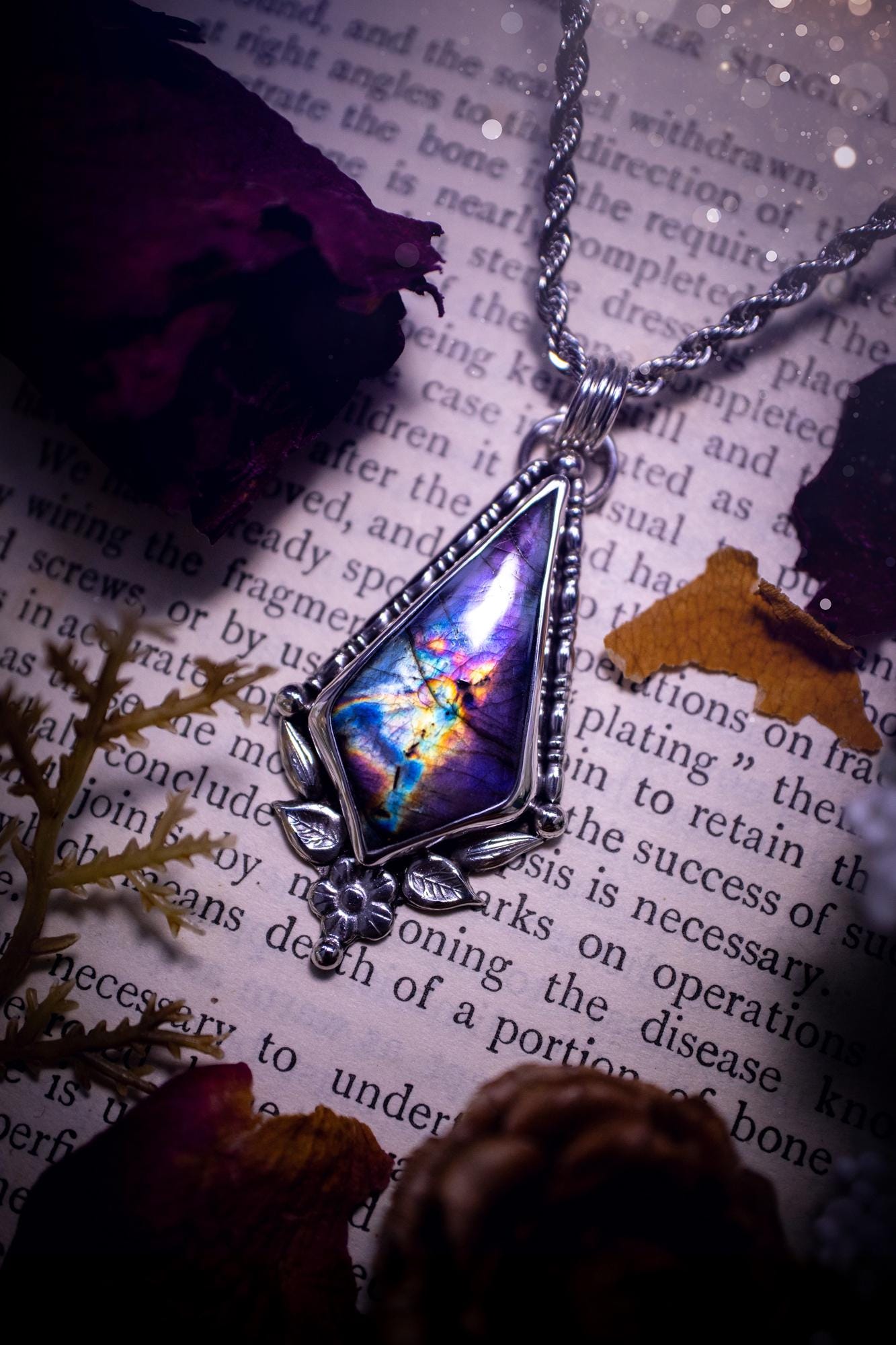 This stunning pendant necklace has been handcrafted using a mix of recycled fine and sterling silver. Featuring a beautiful and natural purple and pink hued labradorite crystal that is full of flash! accompanying this magical crystal is a mix of fae inspired components such as little leaves, flower, silver balls and gothic gallery wire. A true bespoke piece with no other being the same! Ideal for any crystal and jewellery lover that loves a witchy and gothic vibe, along with the beauty of nature